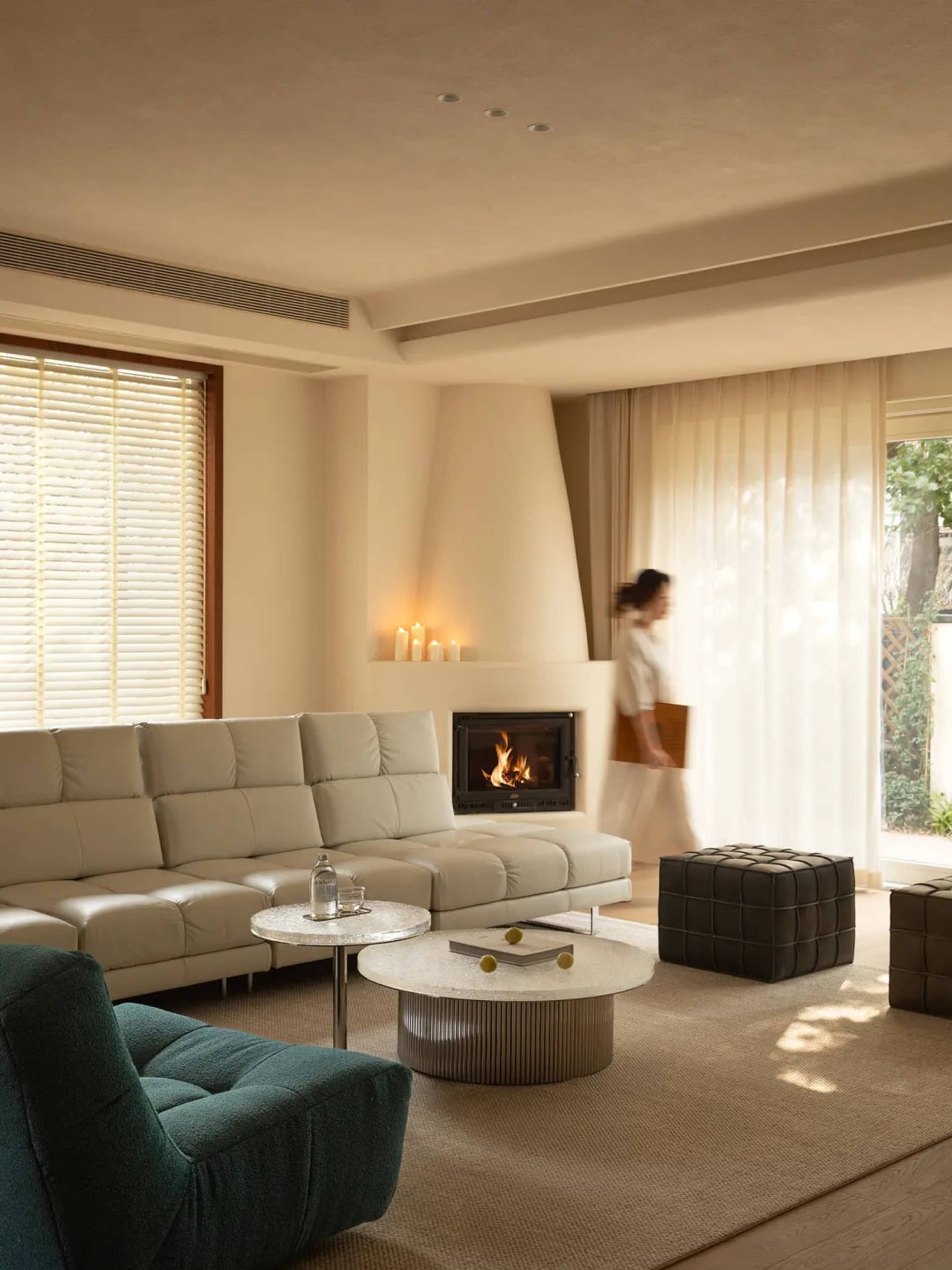 Cozy living room with a fireplace, white furniture, and natural light