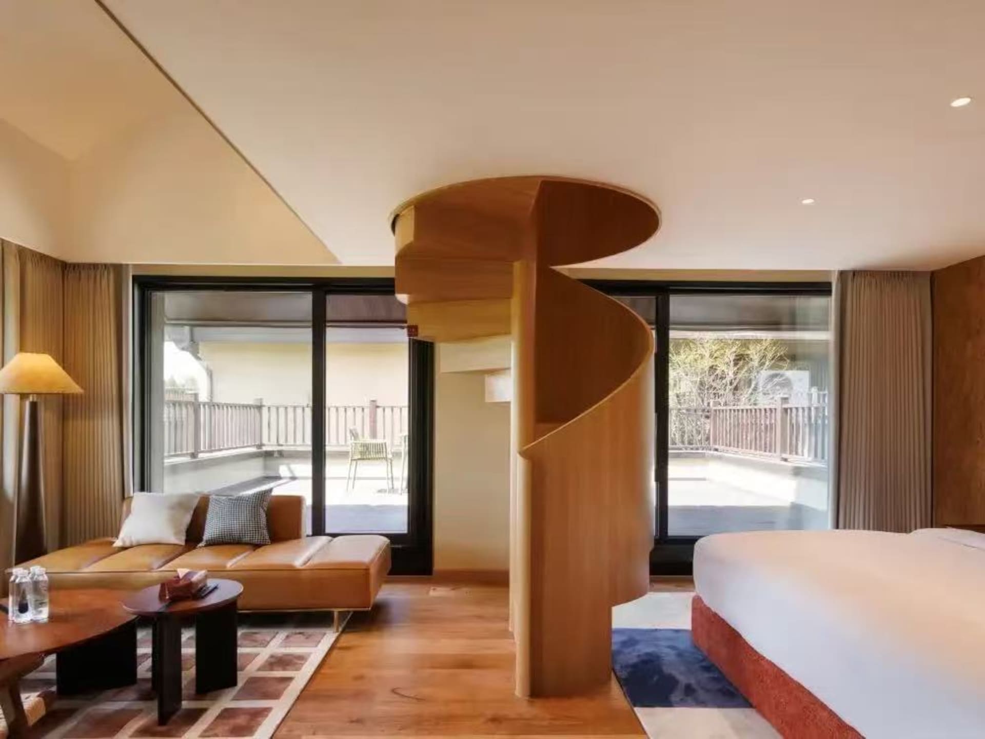 Cozy living room with wooden floors, a spiral staircase, and comfortable furniture