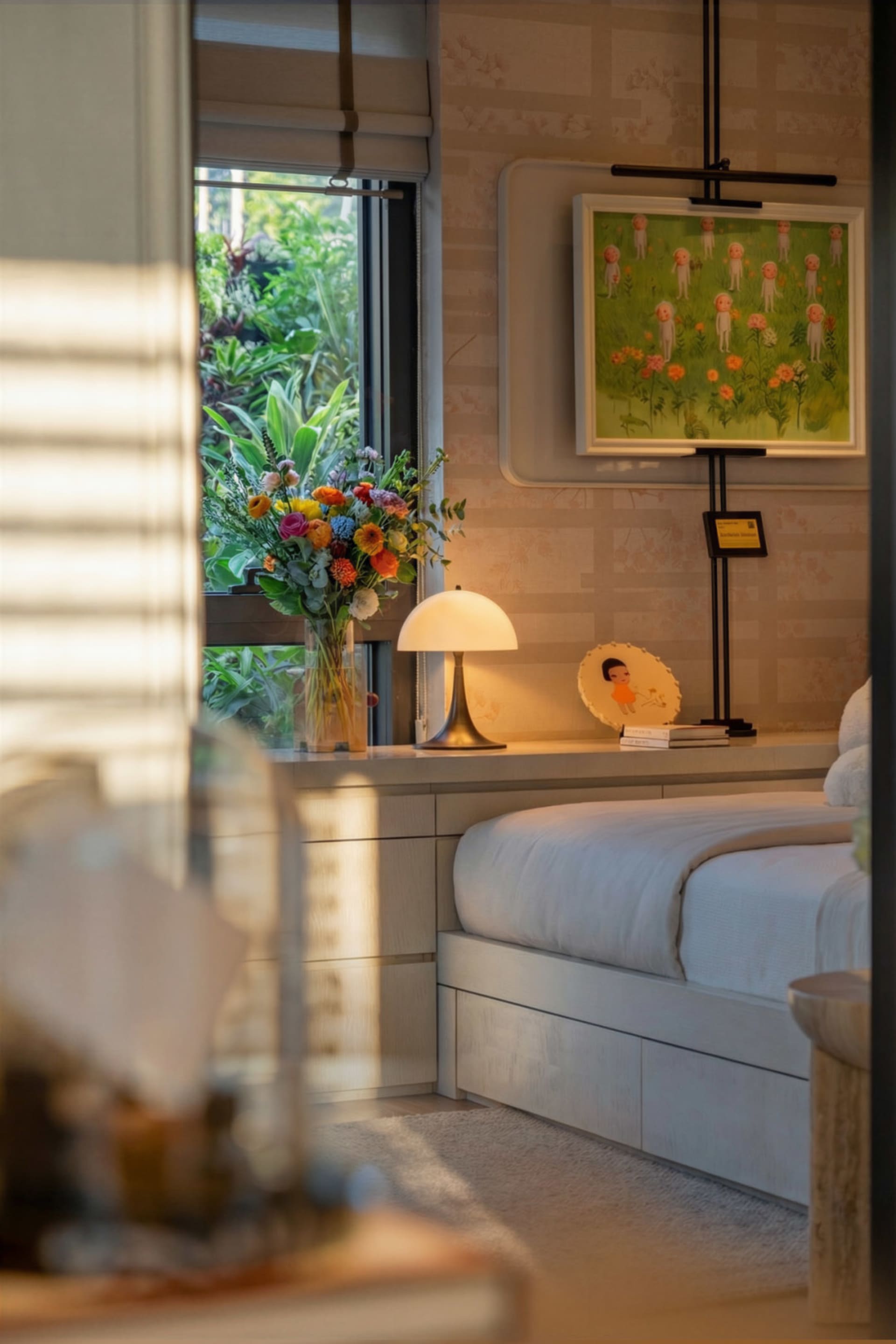 A minimalist bedroom with a white bed, natural light from a window, and additional lighting from a lamp, creating a clean and inviting space