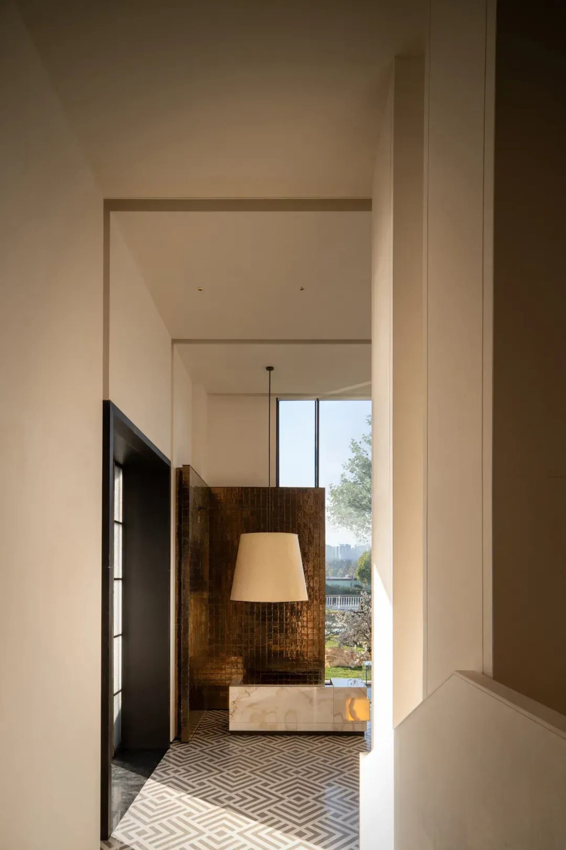 A dimly lit hallway with a black door and a lamp on the wall, shot from a low angle looking up