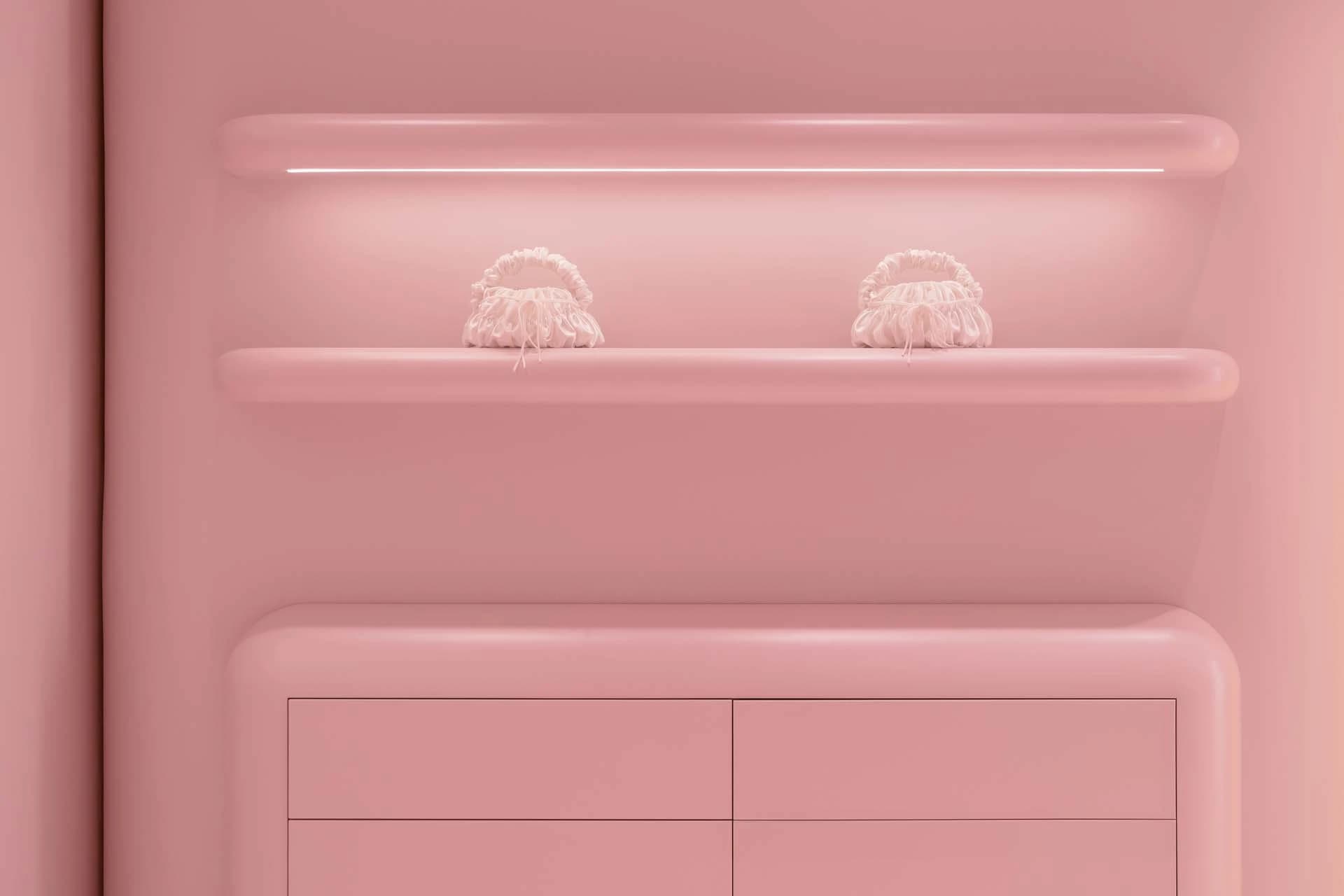 Pink bathroom with two hair dryers on a pink shelf or cabinet in a minimalist space
