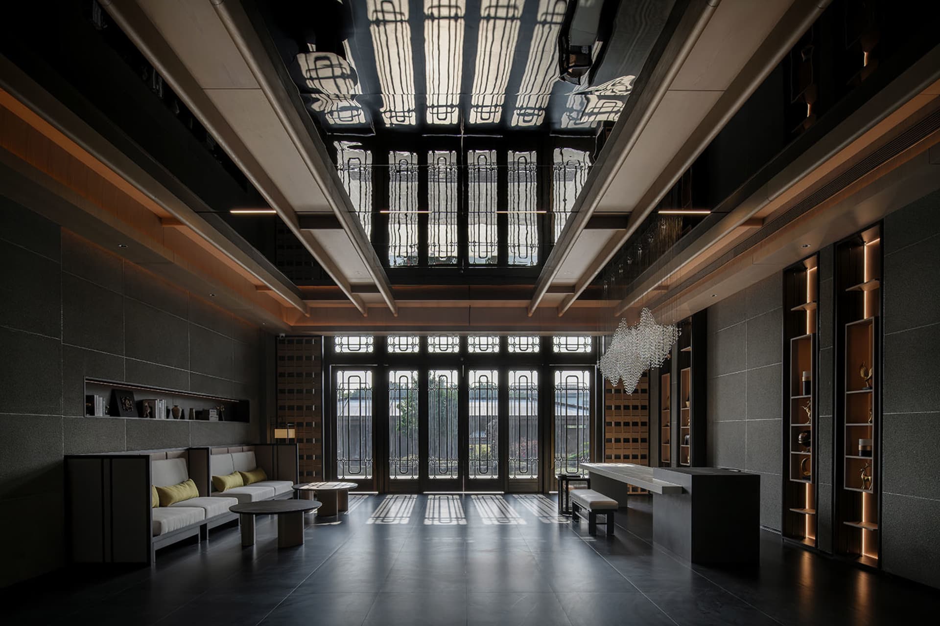 A well-lit, modern living room with a high ceiling, filled with furniture and natural light from a large window