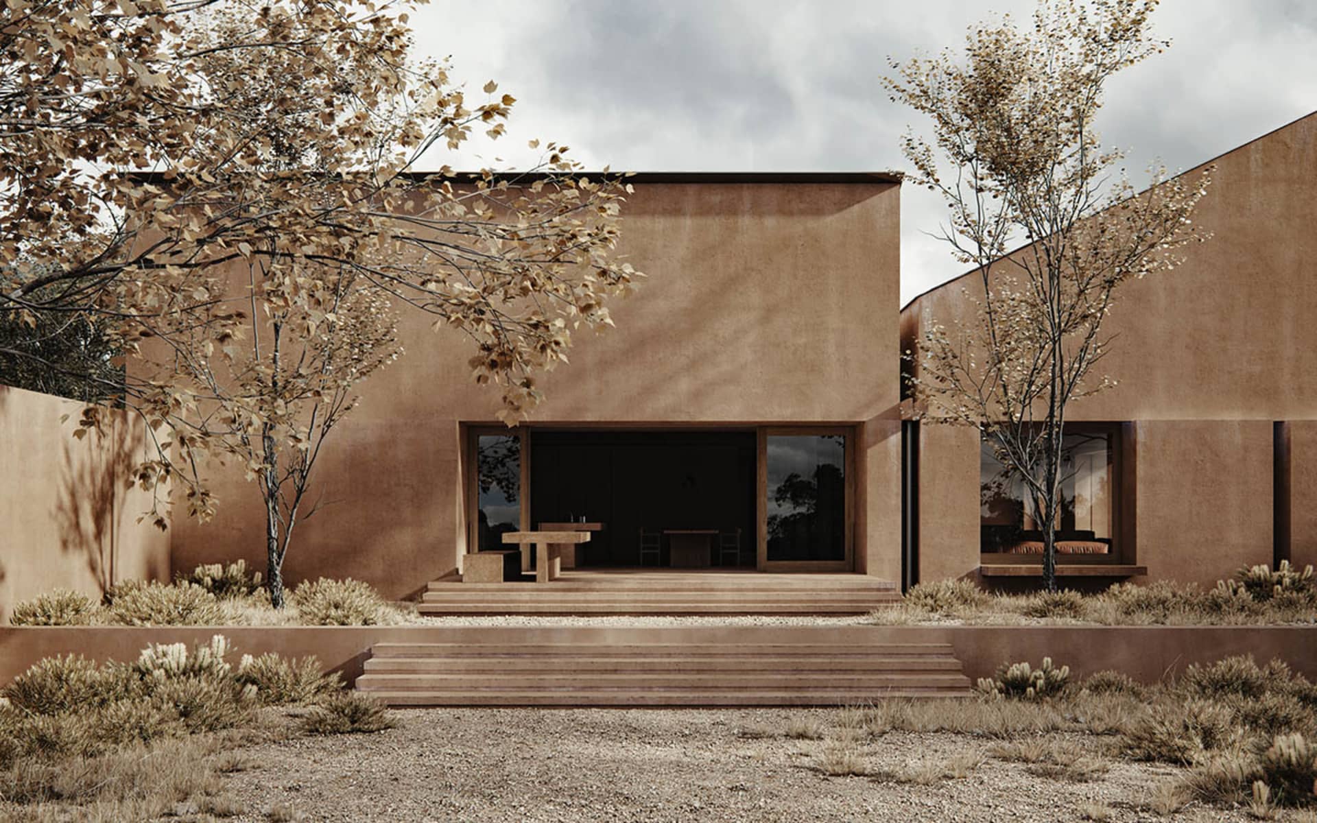 A modern outdoor dining space with a brown house, a dining table, a couch, and a sink, set against a natural background with a tree and sunlight streaming in through the windows