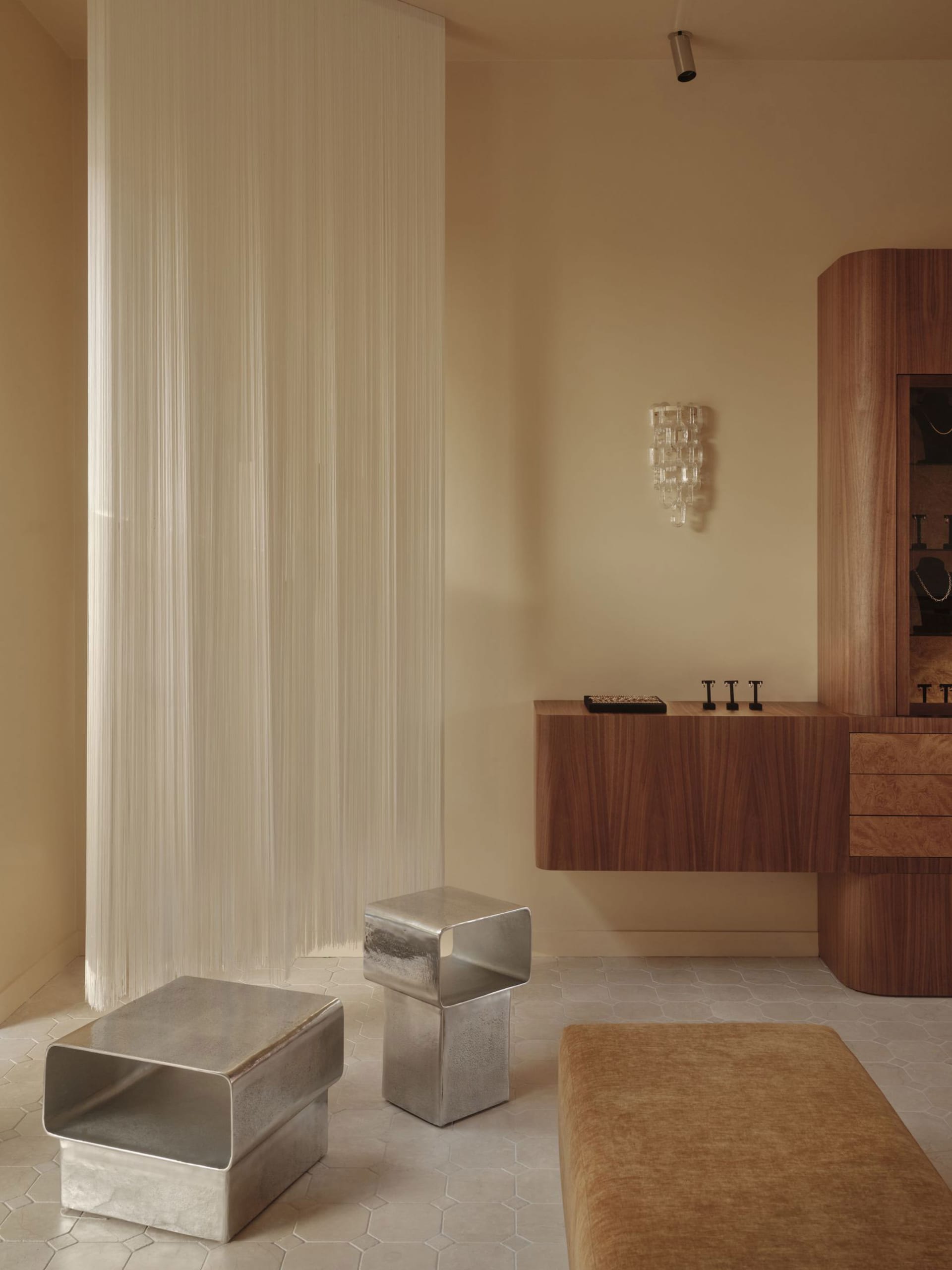 beige bathroom with a wooden vanity, sink, and mirror, surrounded by a couch in a larger living space