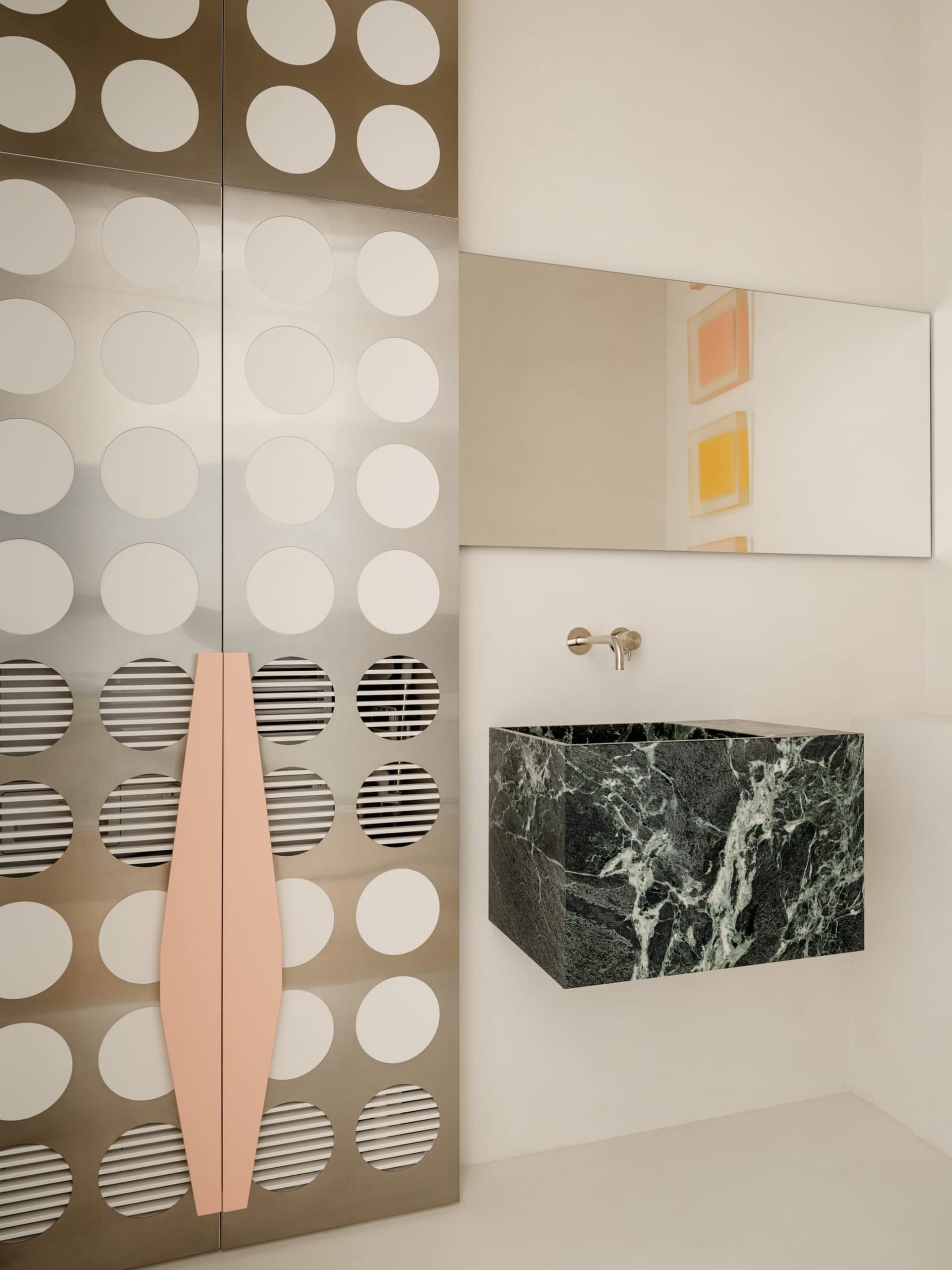 A modern bathroom with a marble sink, a large mirror, and bright lighting, creating a clean and elegant atmosphere