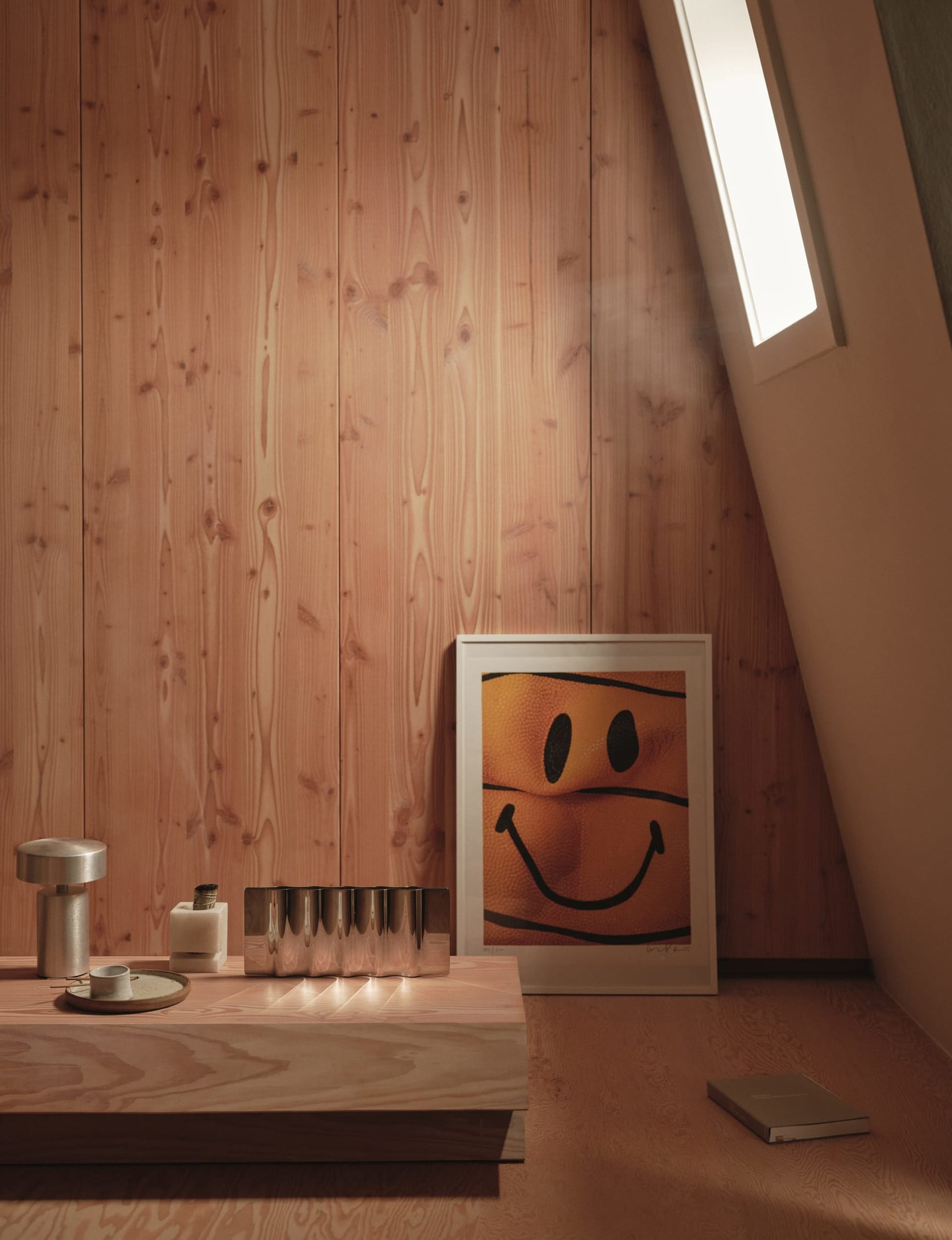 Residential bathroom with wooden walls and floor, featuring a sink, mirror, and a smiley face on the wall, creating a cozy and warm atmosphere