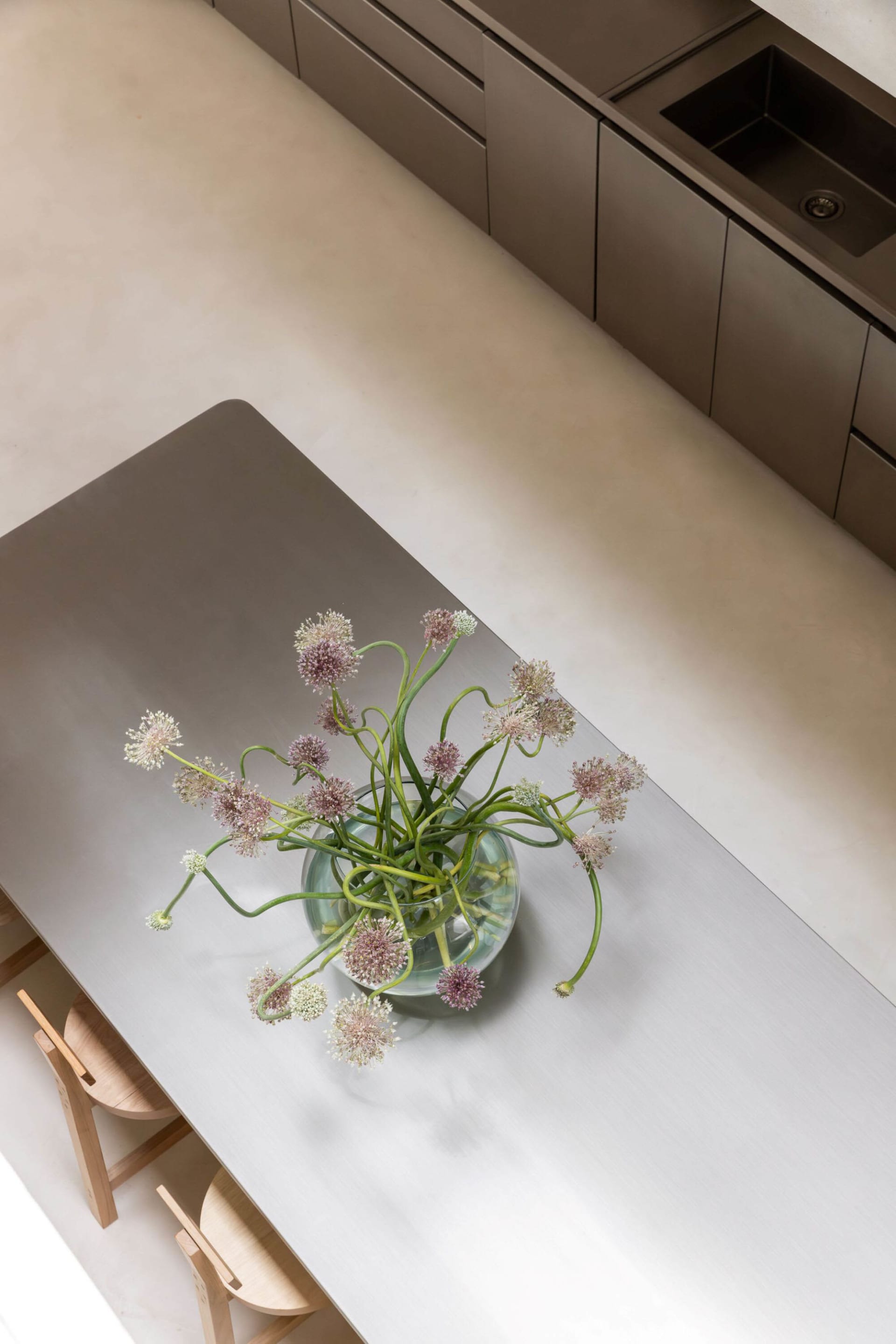 A calm and inviting table setting with a metal table and a vase of purple flowers indoors