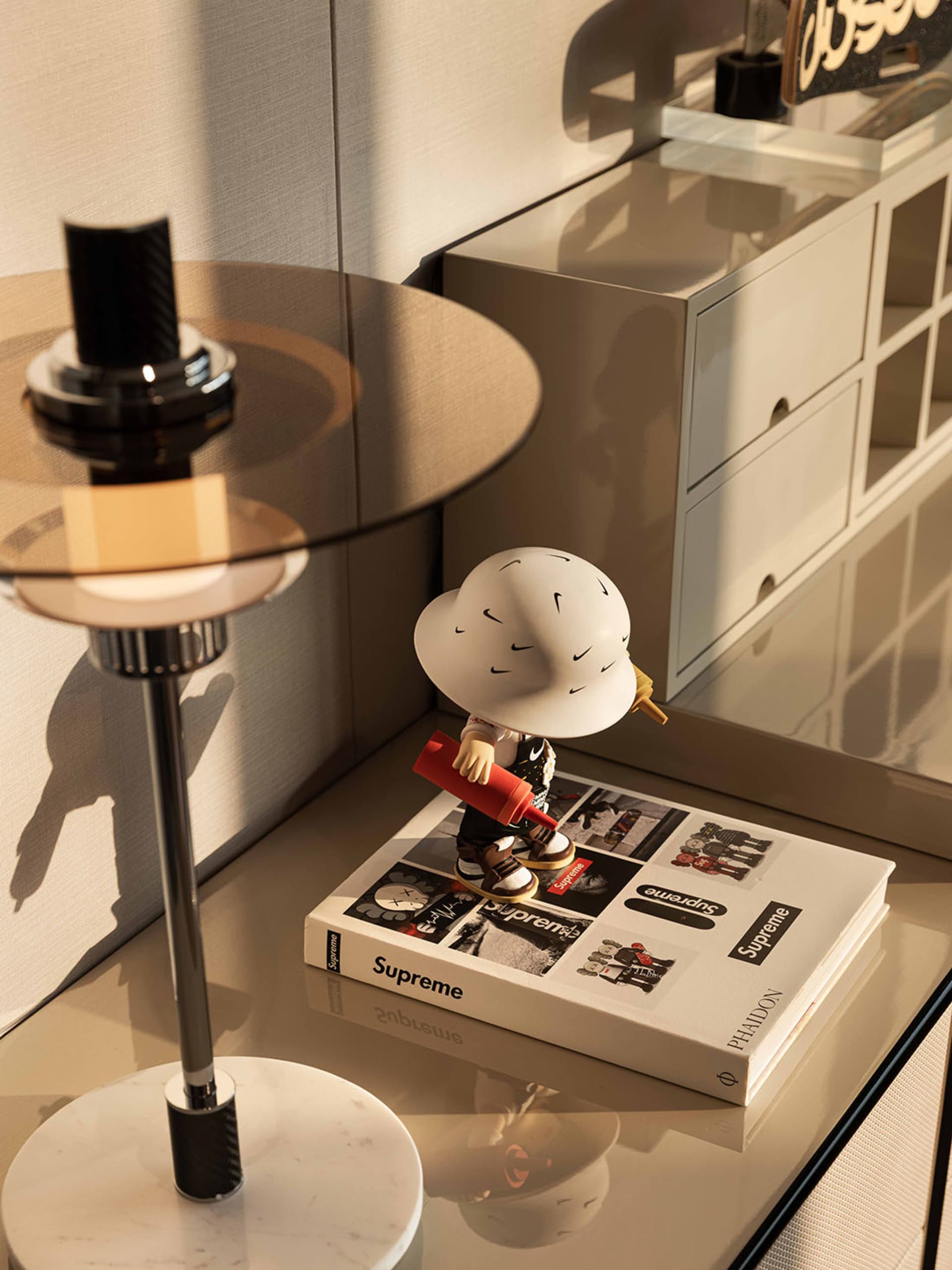 Cozy living space with a white table, a book, and a figurine, surrounded by a couch and a chair