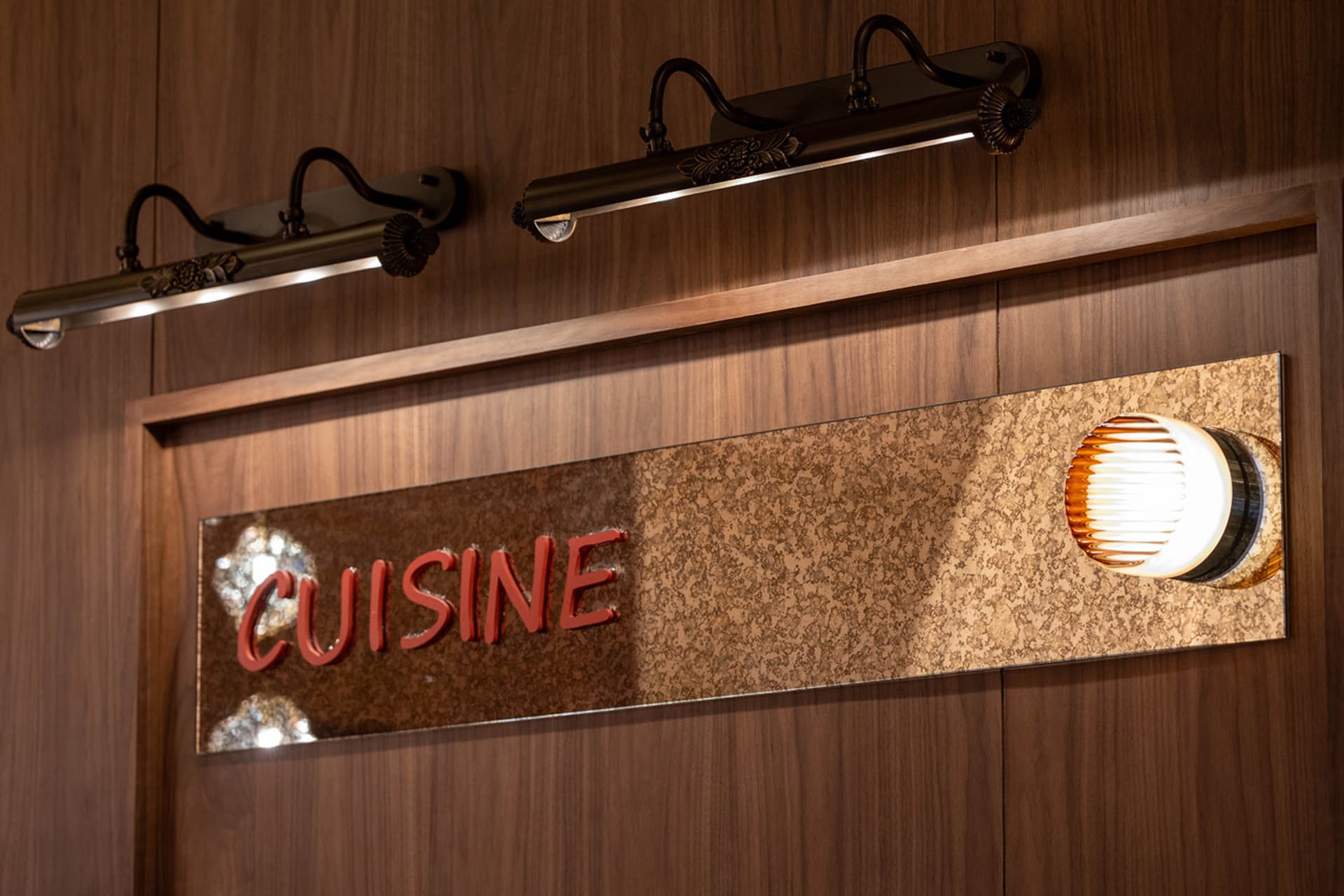一個燈光充足的餐廳，木質招牌上寫著"Cuisine",創造了一個溫暖舒適的氛圍