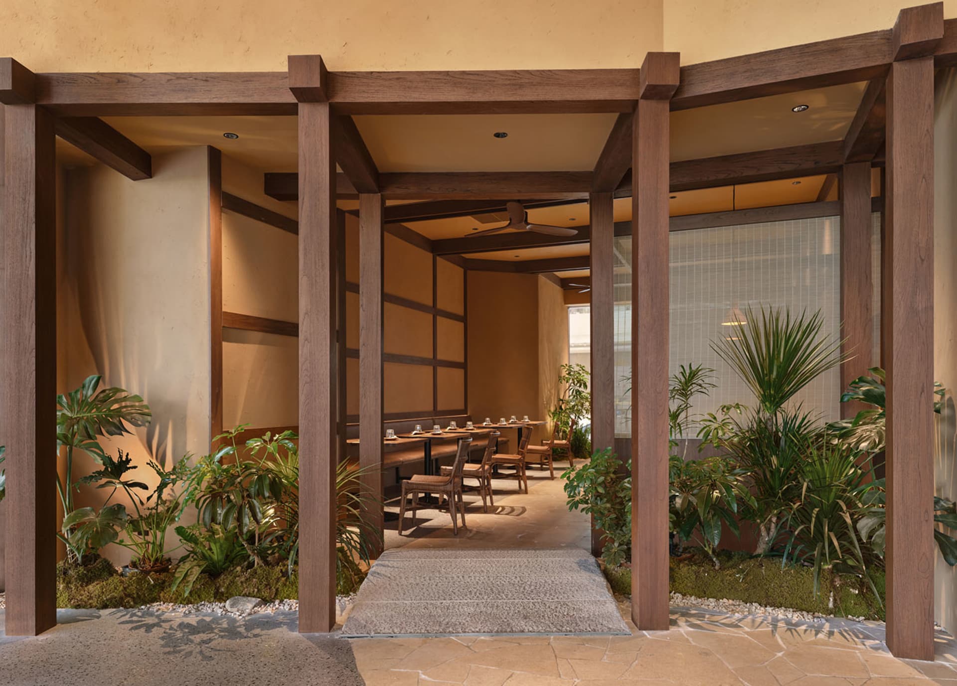 一間現代餐廳的室內設計，地板和天花板都以木材裝潢，室內散佈著植物，配有椅子和餐桌
