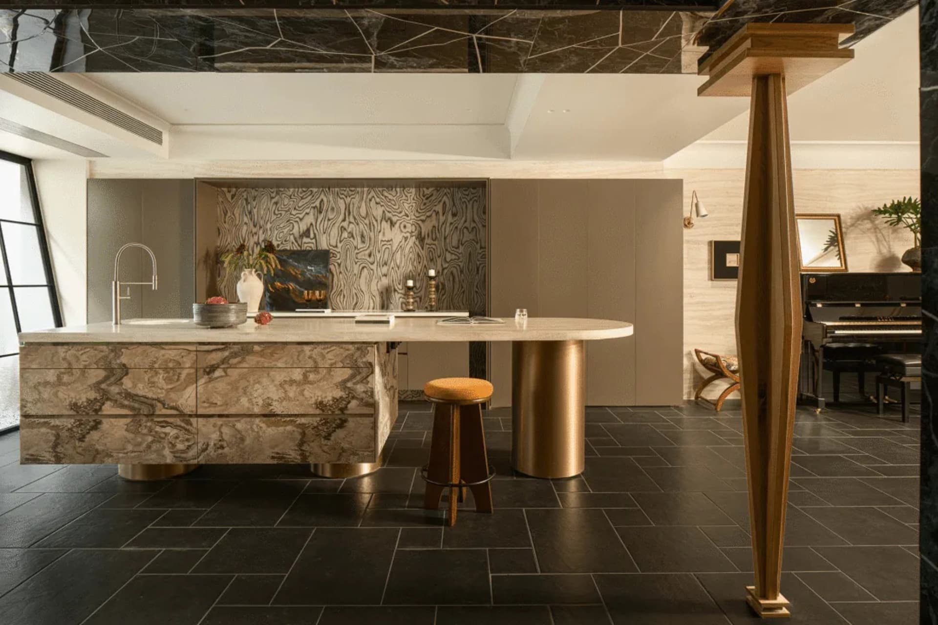 Photograph of a kitchen with a marble countertop, gold barstool, and natural lighting creating a warm and inviting atmosphere