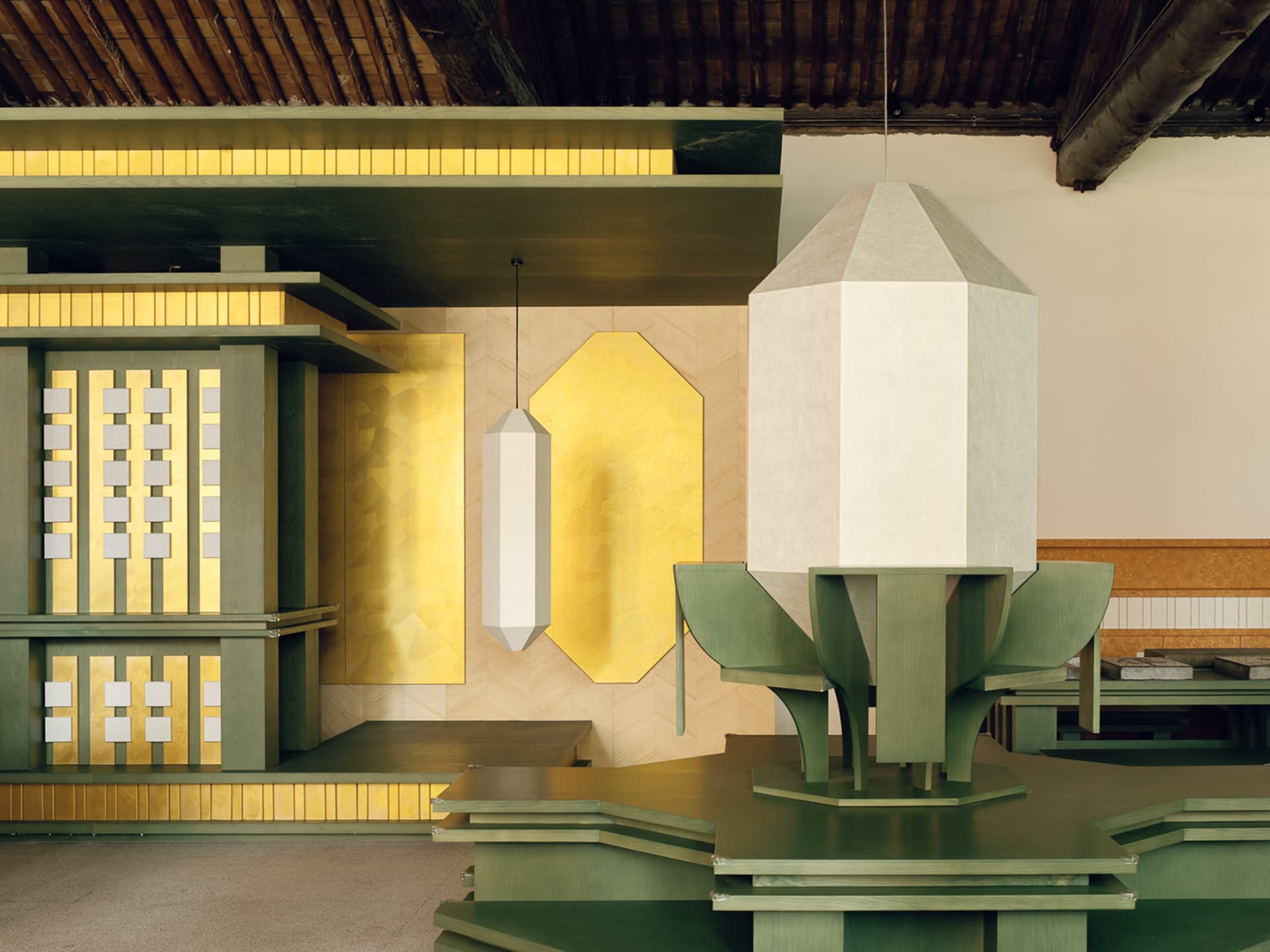 A dining area with a green table, white lamp, and dim lighting, creating a cozy and intimate atmosphere