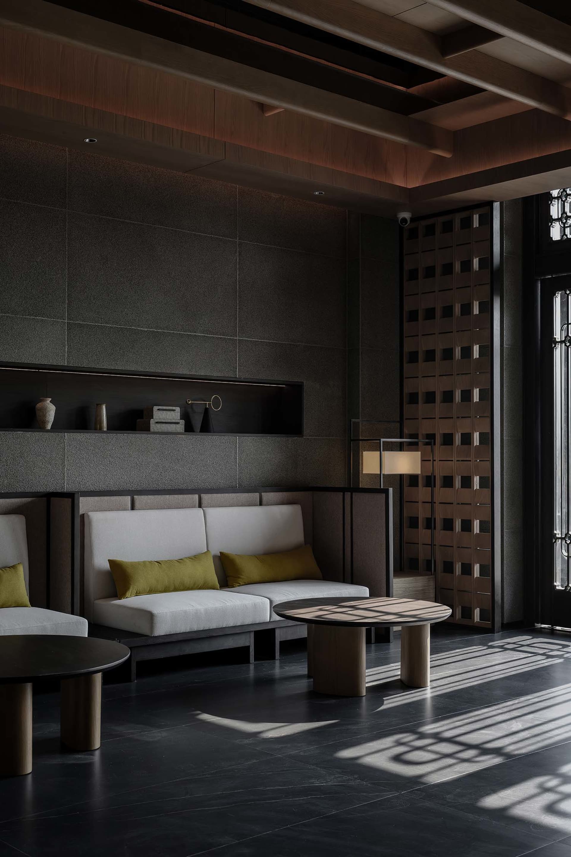Comfortable living room with a large couch, chair, and coffee table, well-lit with a vase on a surface, in a contemporary and stylish space