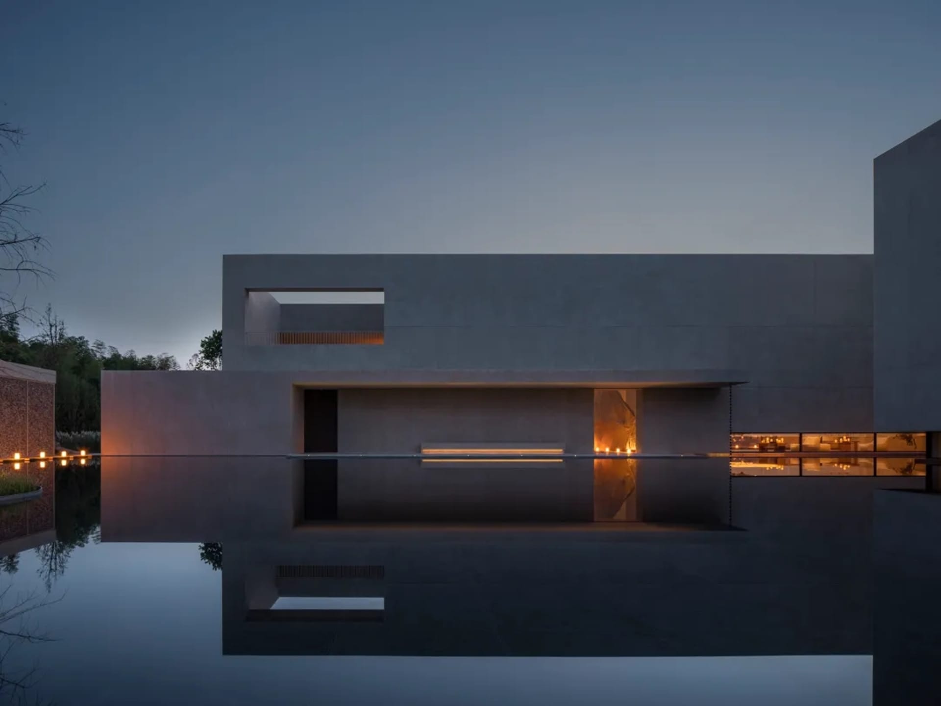 A large modern building with a glass exterior reflected in a pool of water, creating a visually striking scene with a sense of elegance and sophistication