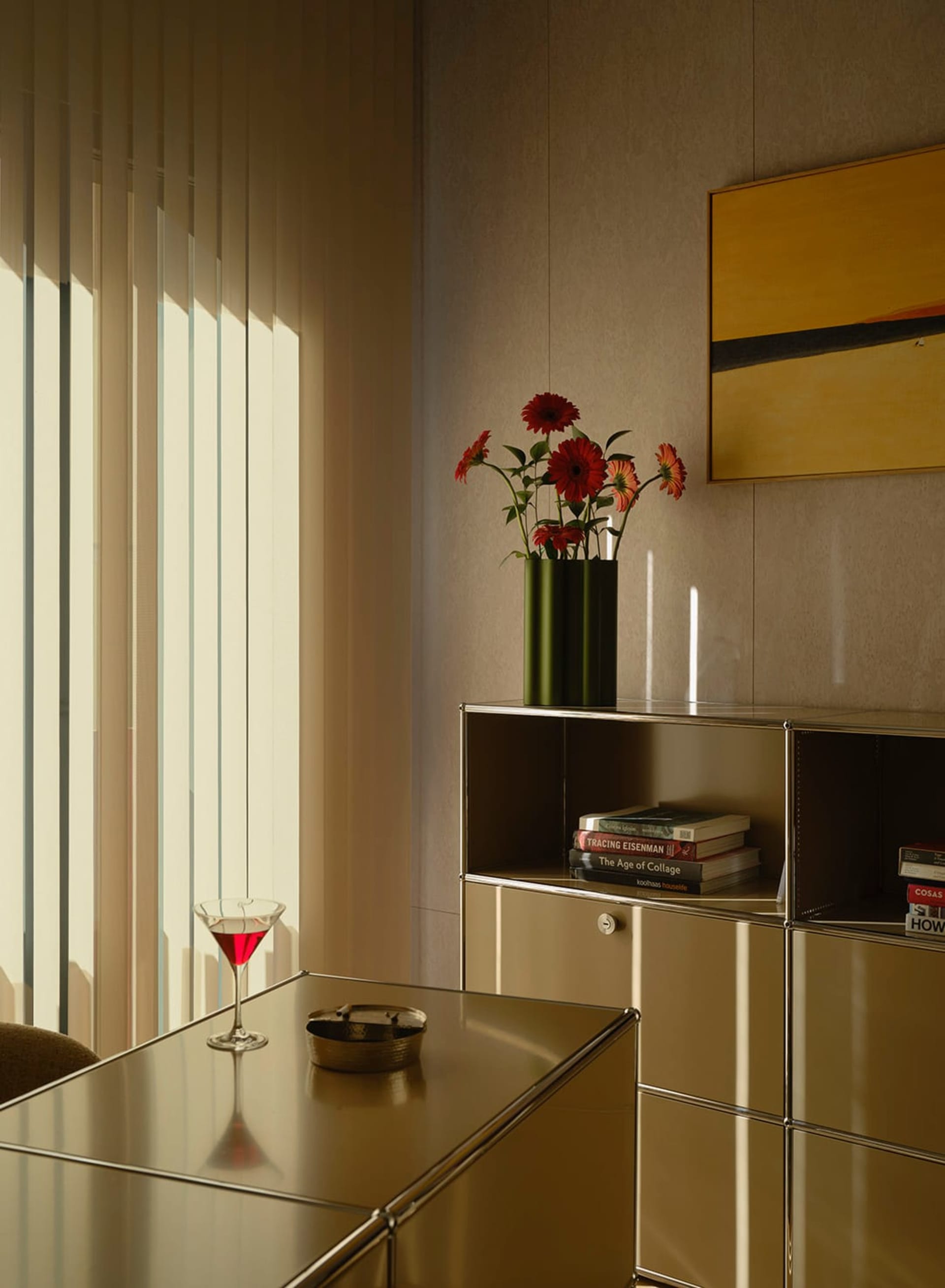 Cozy living room with a yellow color scheme, wooden furniture, and dim lighting, featuring a dining table, chair, vase, martini glass, bowl, and book
