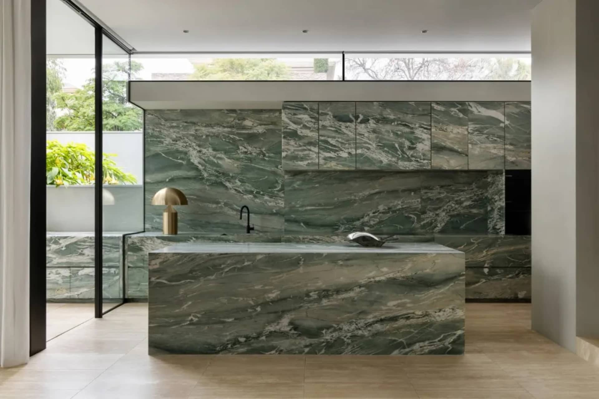Bright and inviting modern kitchen with a marble countertop, natural light, and a sink