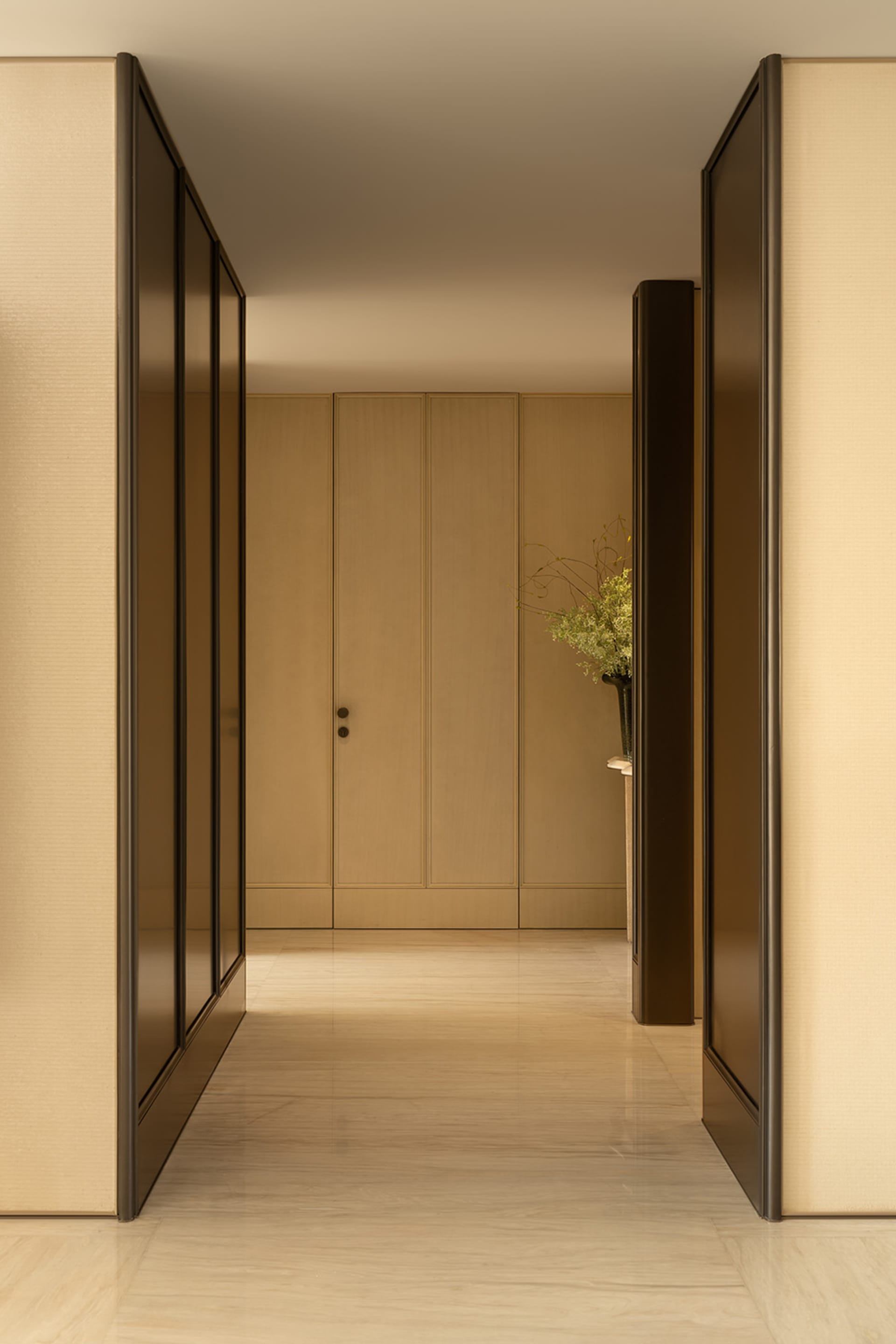 A well-lit hallway with a wooden door and cabinet, creating a warm and inviting atmosphere
