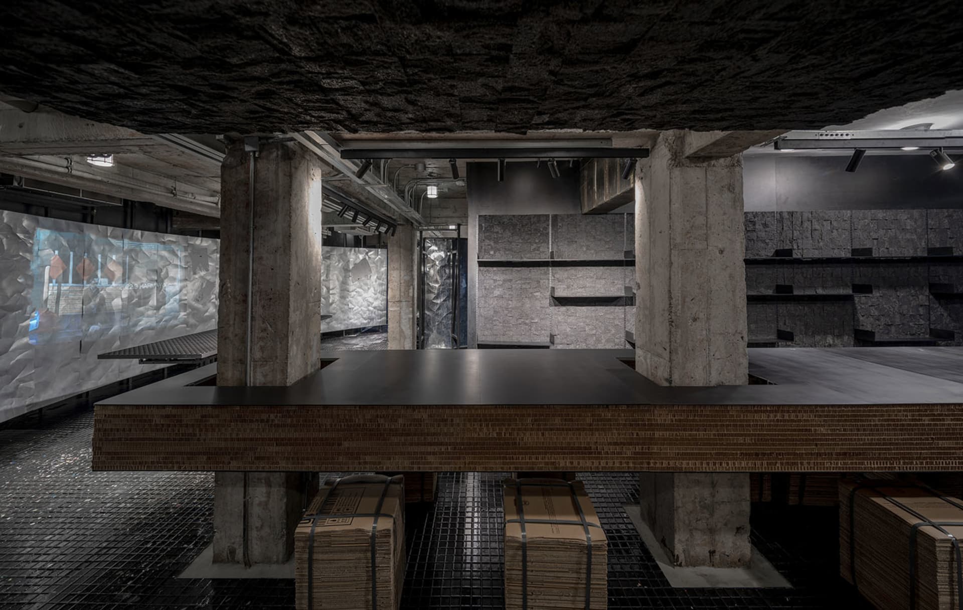 Cozy kitchen dining space with a stone wall, wooden table, and wooden storage boxes, dimly lit