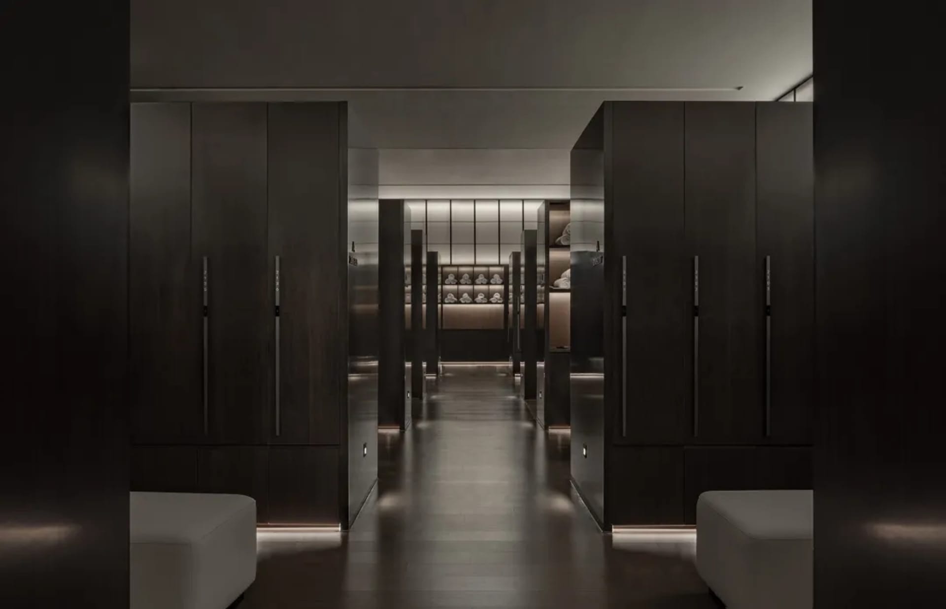 A dimly lit hallway with dark wood cabinets and doors, creating a classic and elegant atmosphere