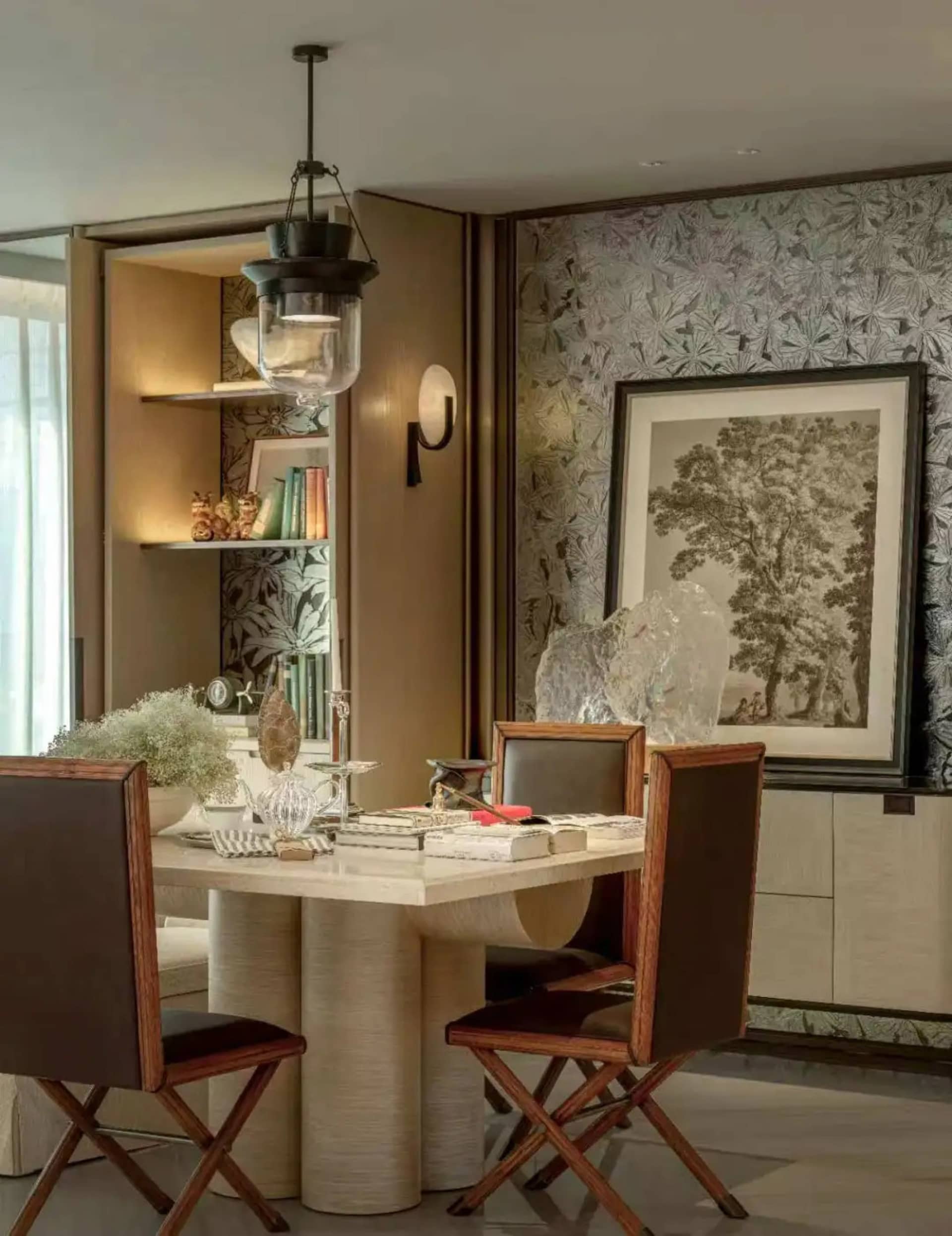 A modern living room with a dining table and chairs, surrounded by books and a potted plant, with a warm and inviting atmosphere