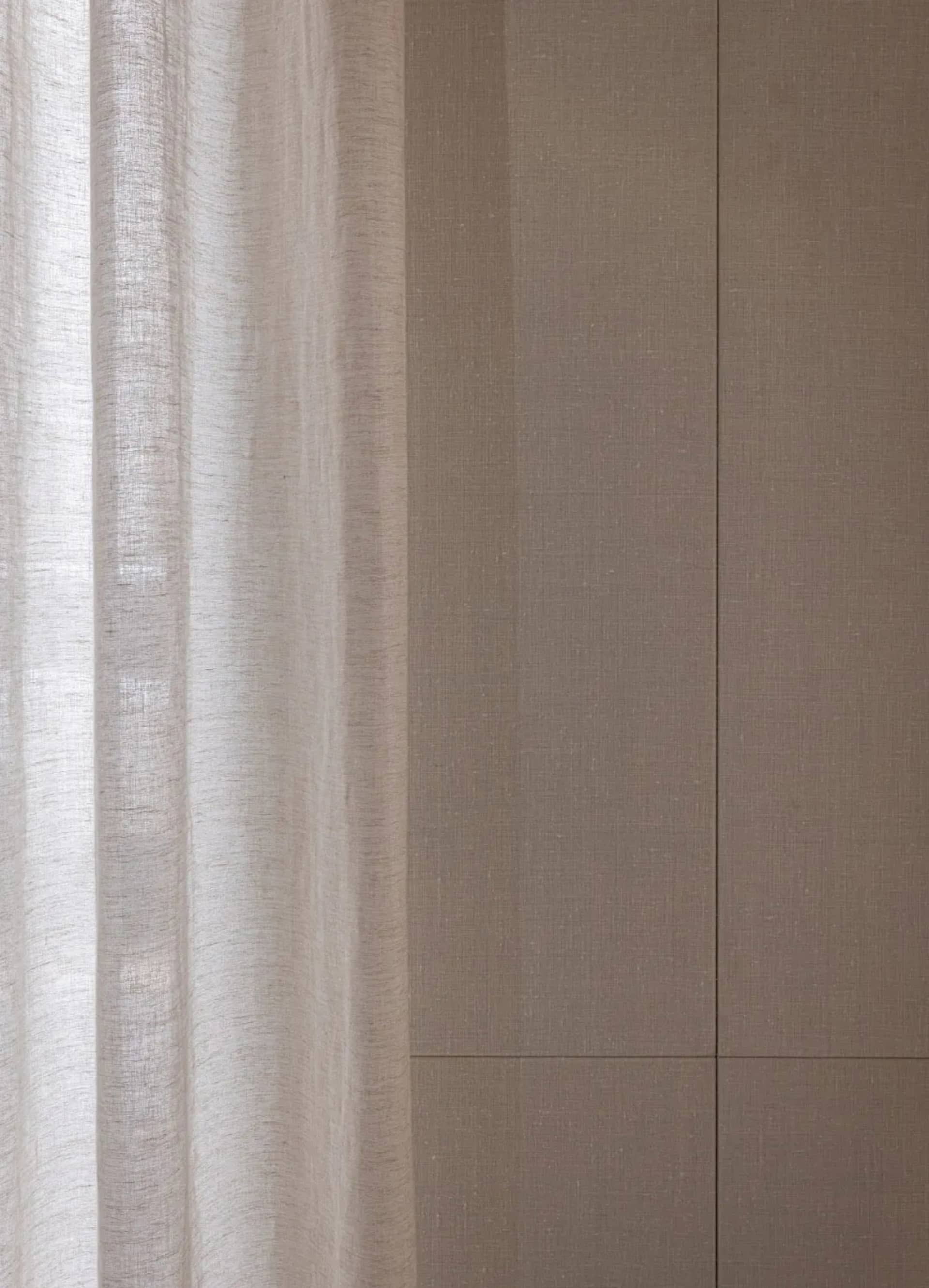 Dimly lit living room with a white curtain covering the window