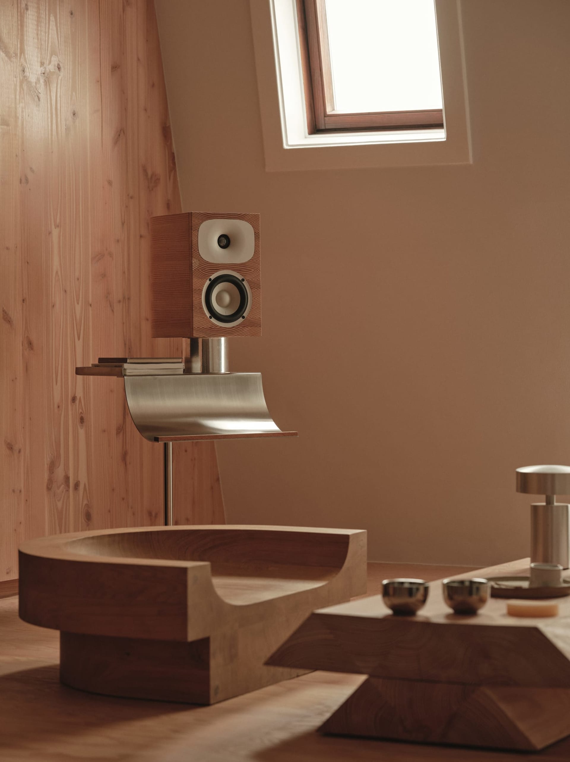 Bathroom with a wooden bench, sink, and window, featuring natural light and a warm atmosphere