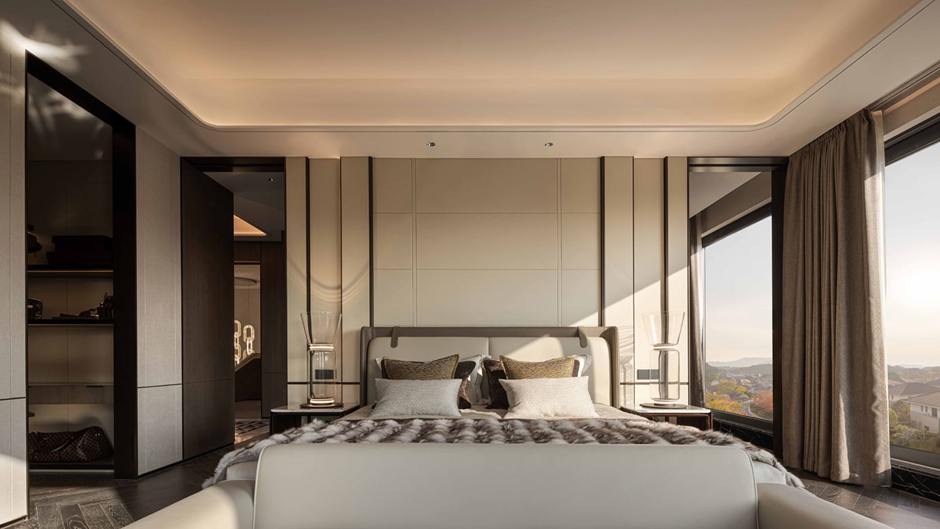 Cozy bedroom with a large bed, a chair, and a couch in a modern space with white walls and soft warm lighting