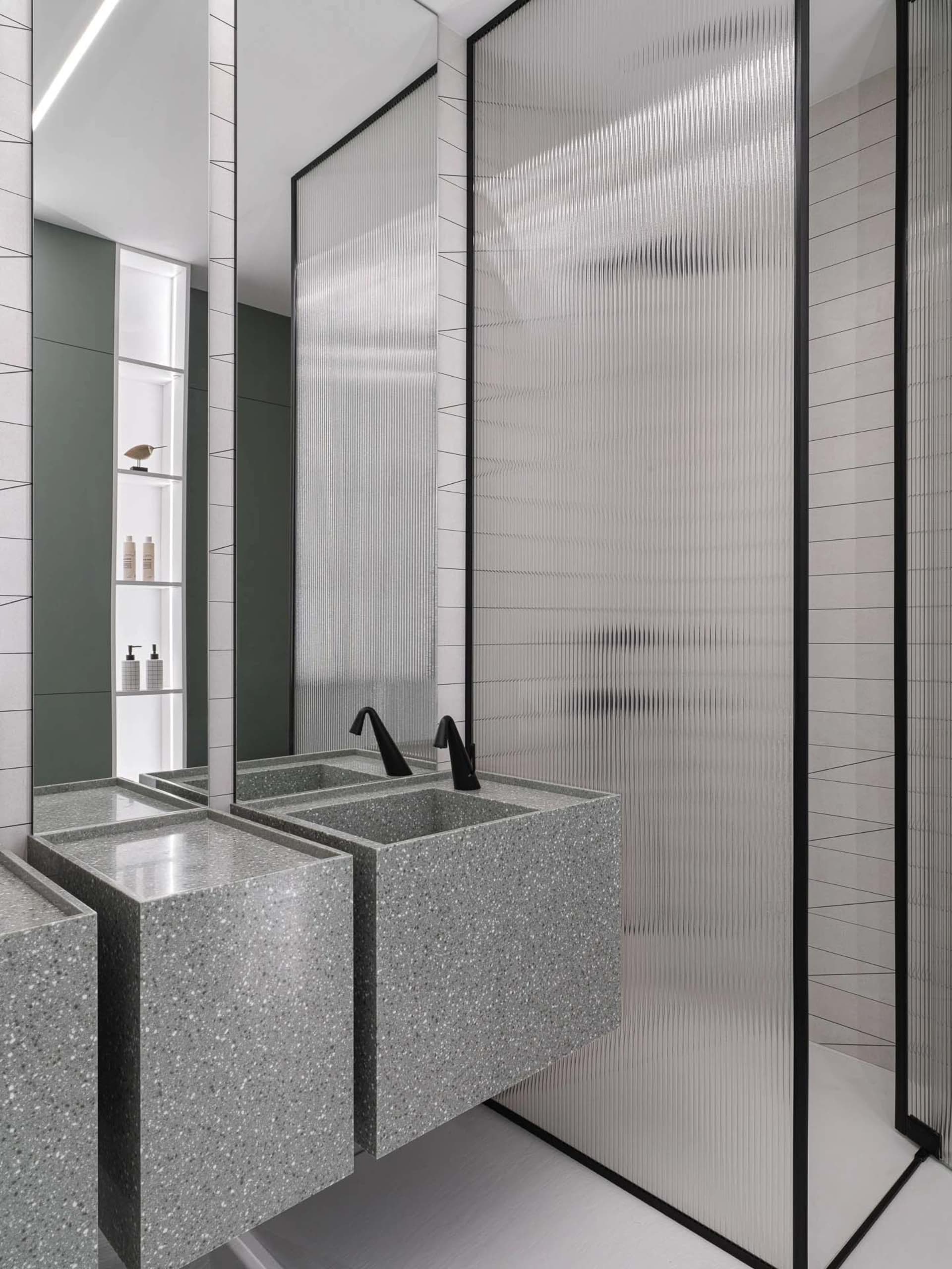 Bathroom with a marble sink and a large mirror above, set in a well-lit space