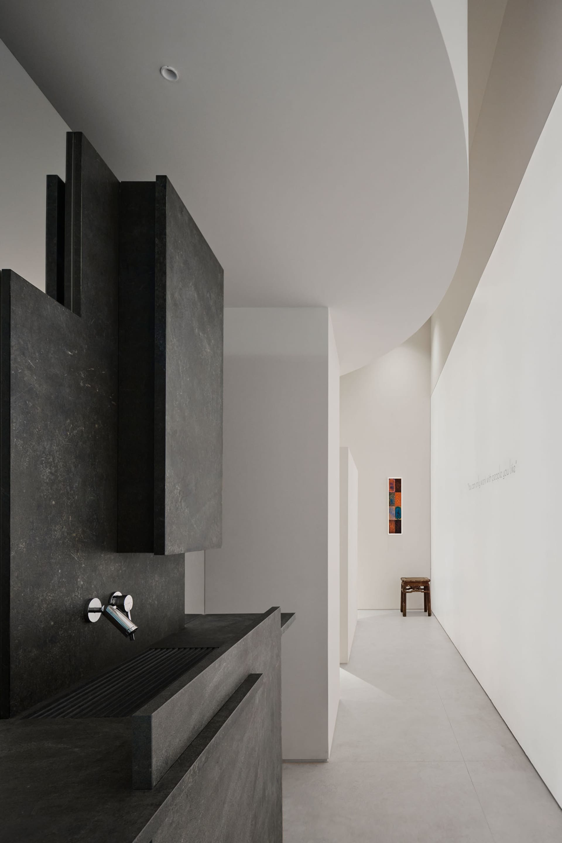 A modern kitchen with a concrete counter, sink, and dim lighting creating a cozy atmosphere