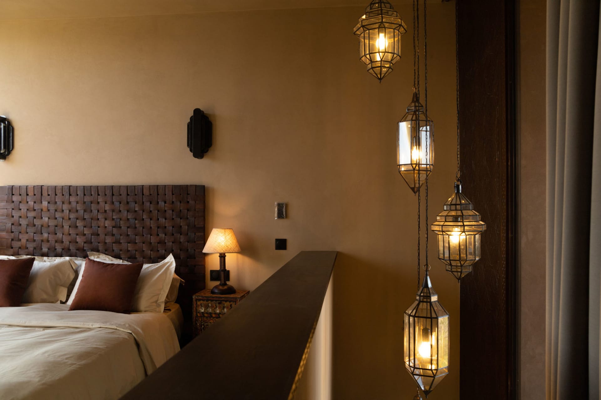 Cozy bedroom with a brown color scheme, a bed, a lamp, and a nightstand, with dim lighting creating a relaxing atmosphere