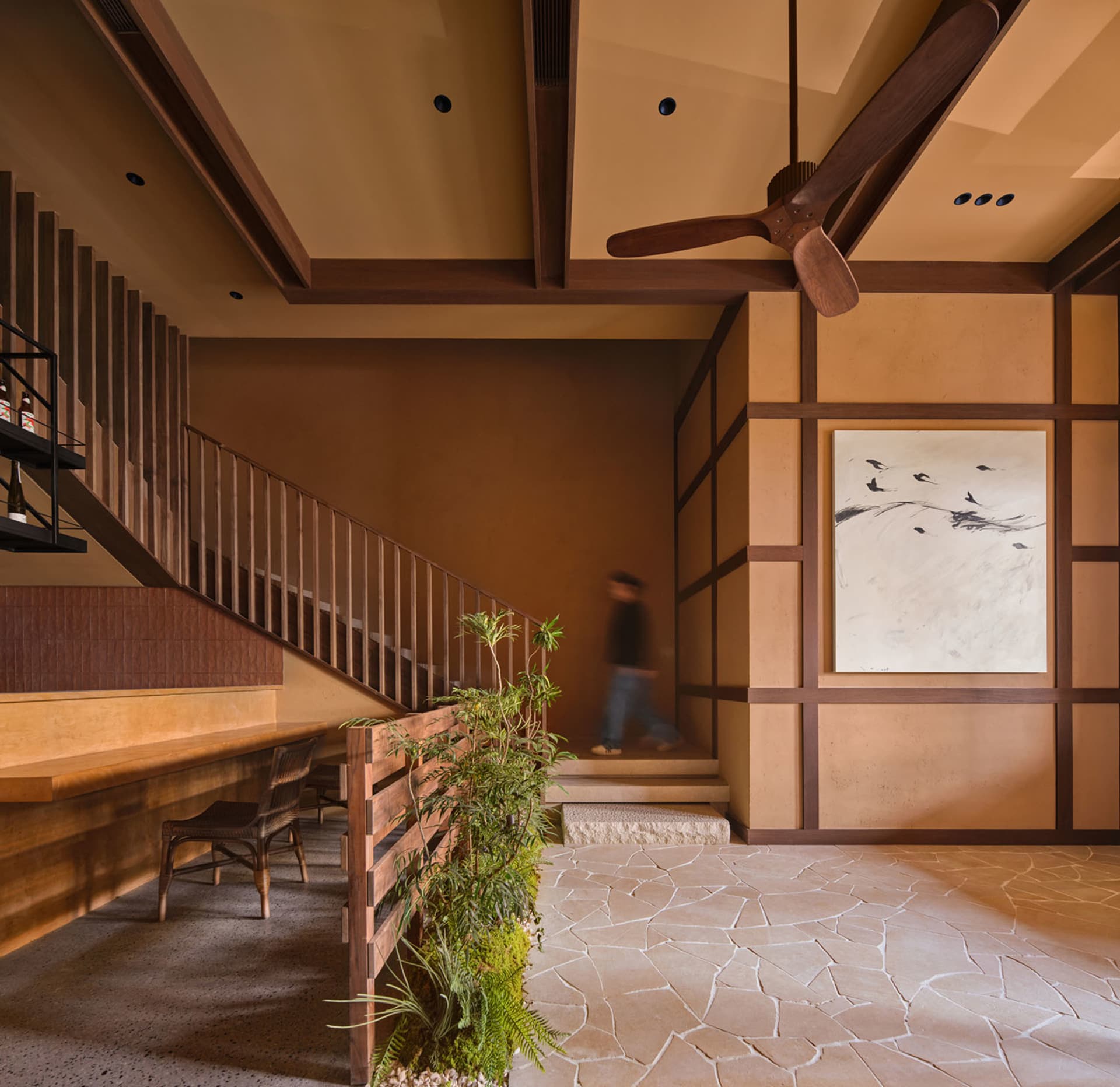 Dining room with wooden floor, staircase, and traditional furniture, well-lit with natural light from a window
