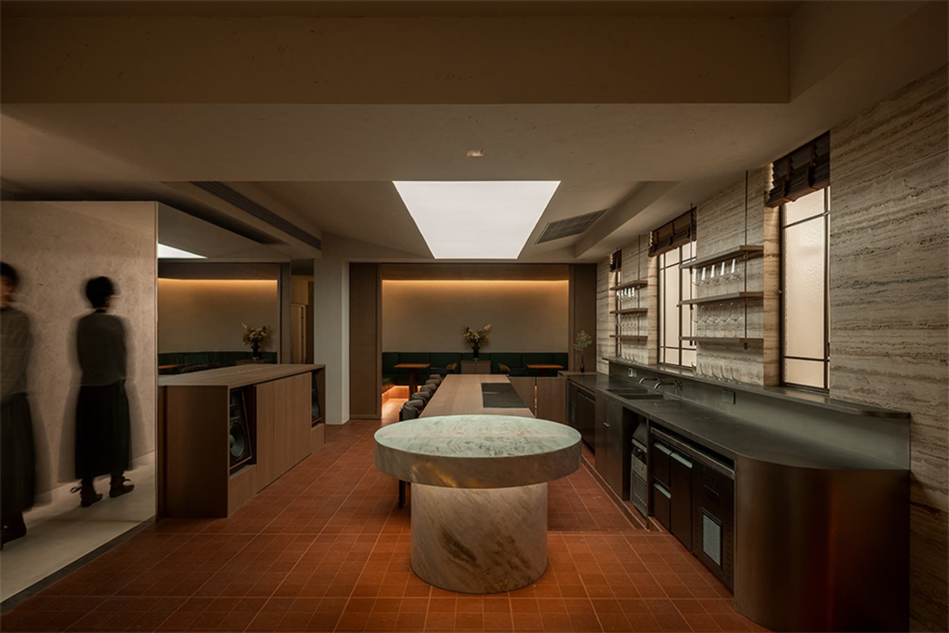Modern kitchen with a marble countertop, large window, and various appliances, creating a bright and inviting atmosphere