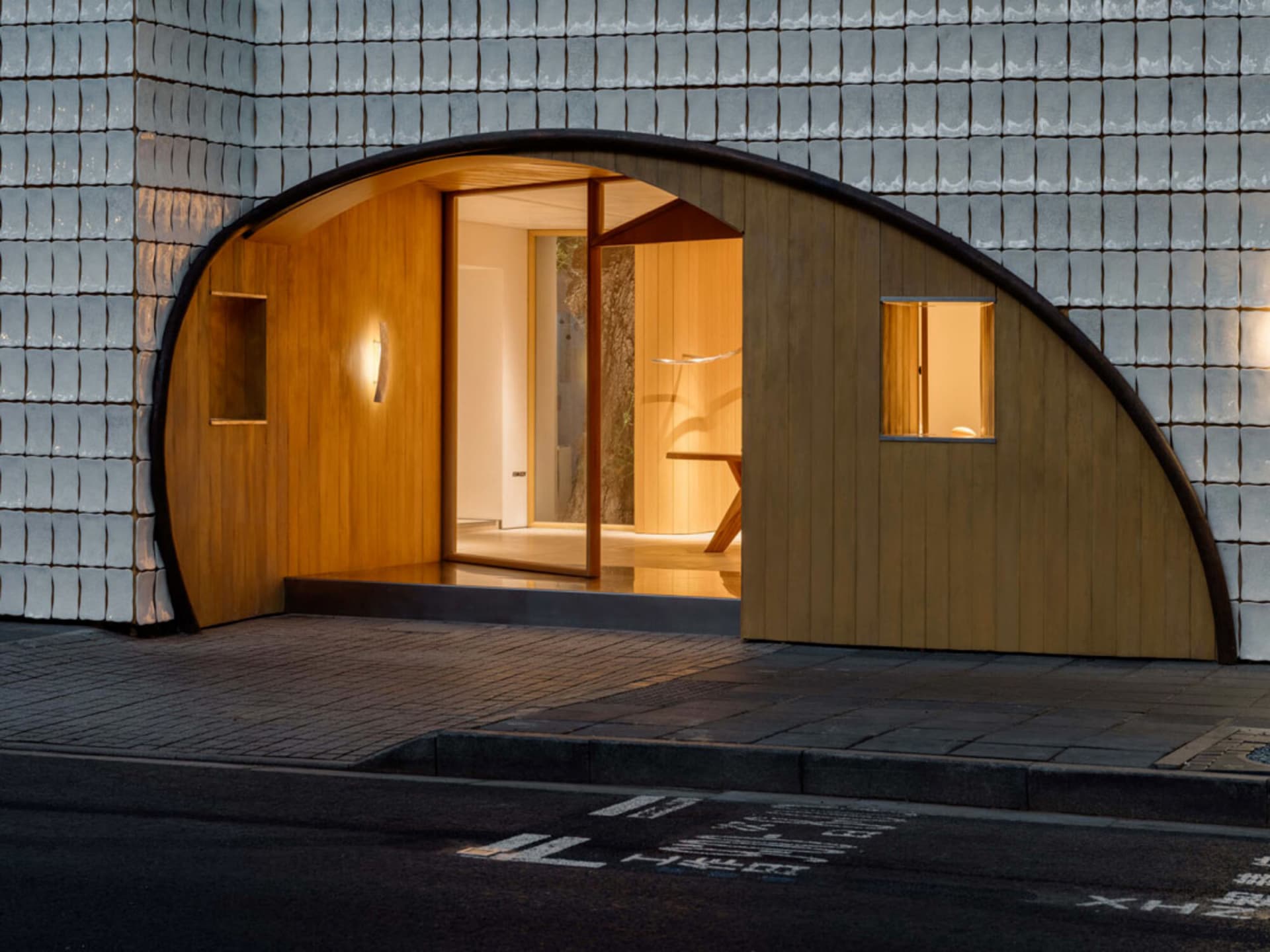 Small, dimly lit room with a wooden floor, door, and window, creating a cozy atmosphere