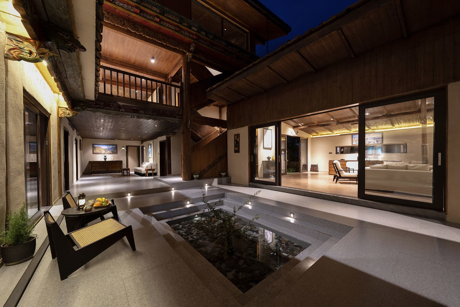 A modern house with a large open floor plan featuring a living room, dining room, and kitchen area with a staircase leading to the upper floor, well-lit and creating a warm and inviting atmosphere