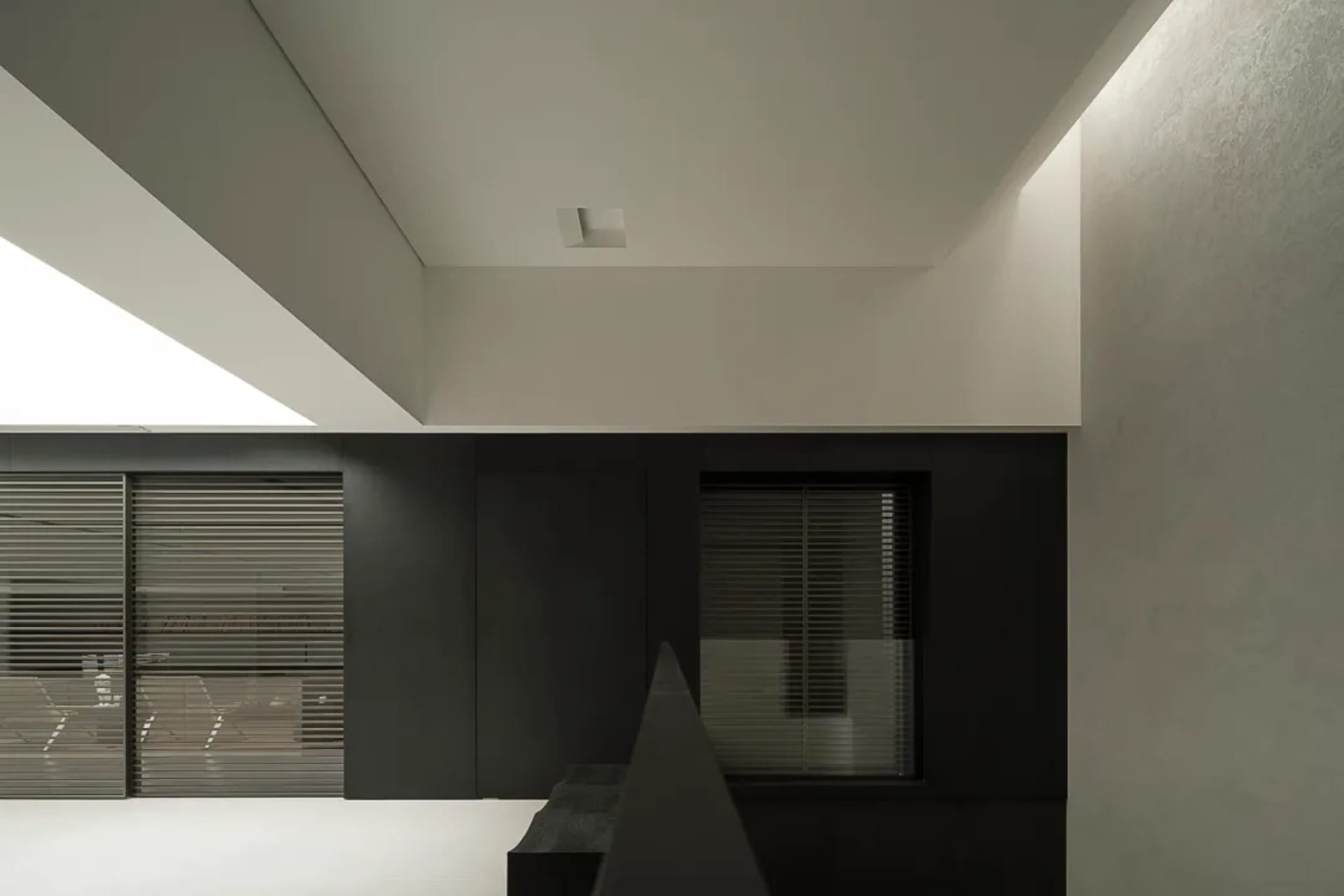 A dark and moody kitchen with a black and white color scheme, featuring a window on the right and a sink on the left