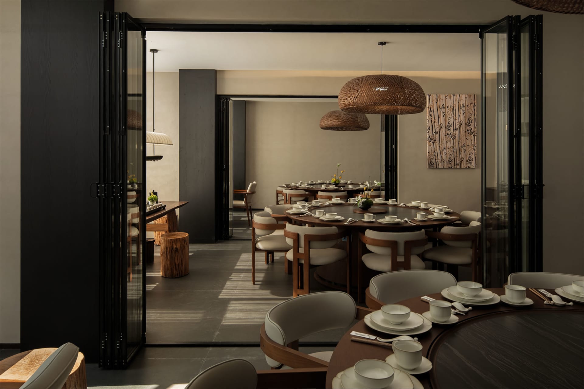 A modern restaurant with a large dining area filled with chairs and tables, set with white tableware, creating a cozy atmosphere
