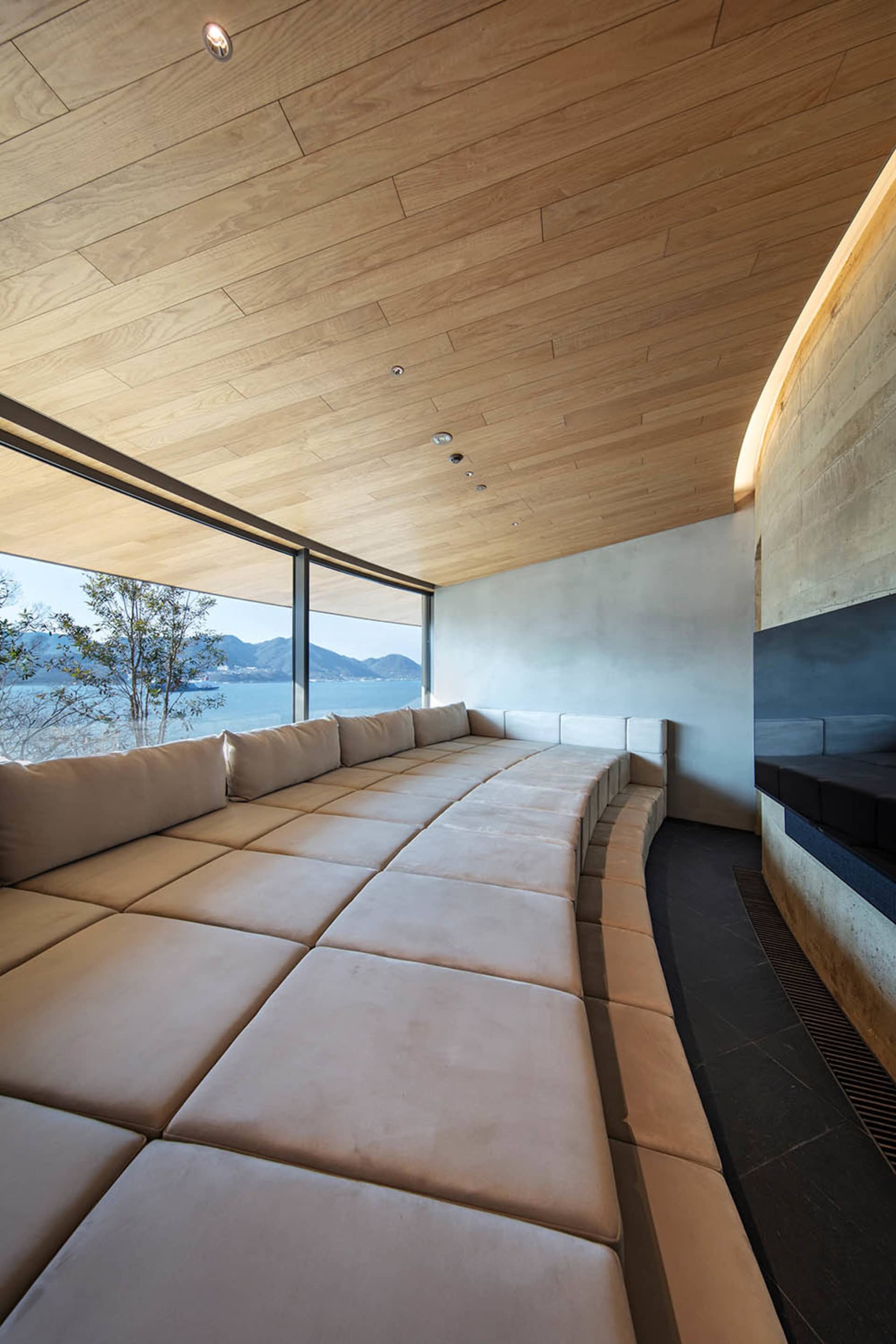 A modern living room with a large couch and chair, natural light, and a bright atmosphere