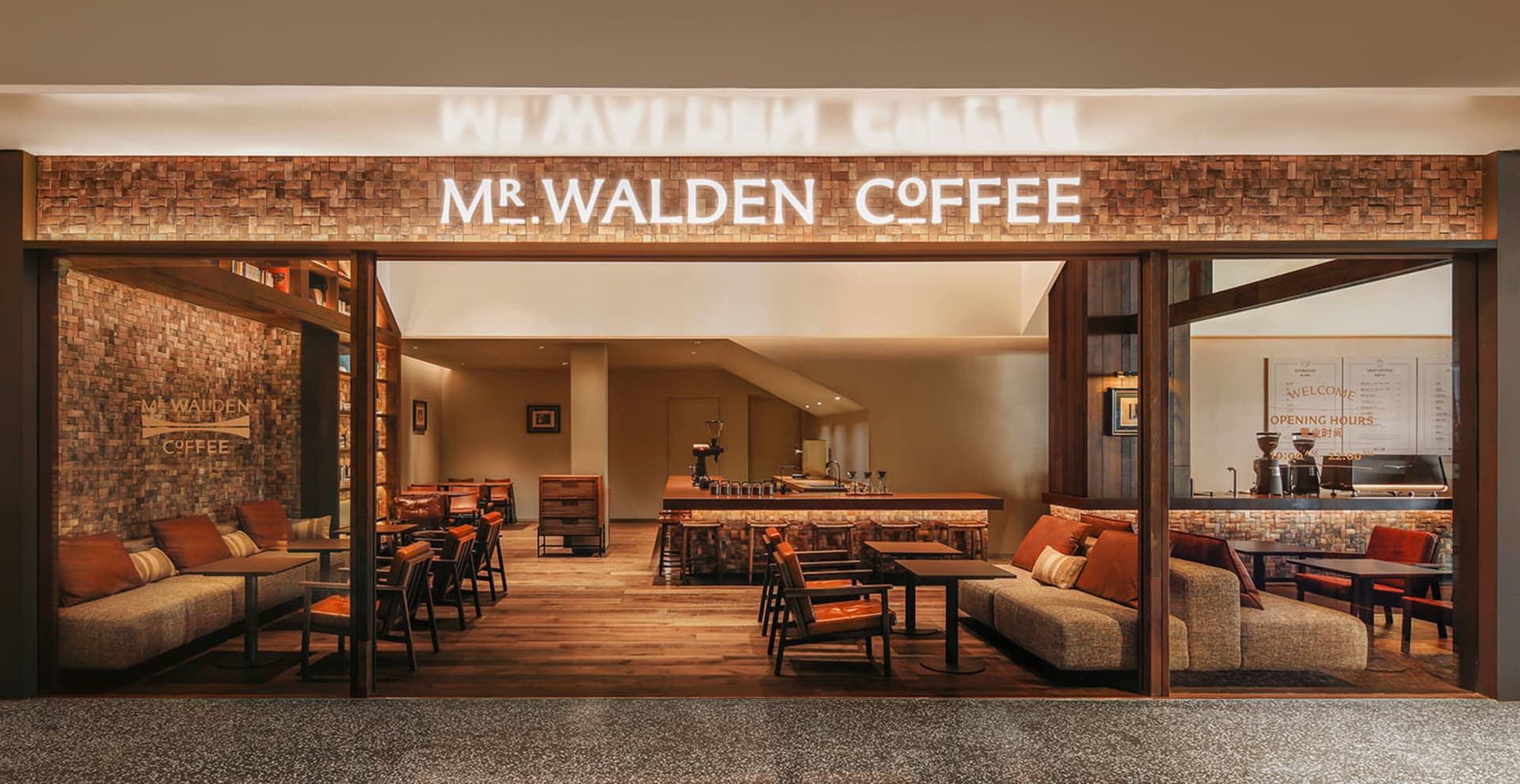 A well-lit coffee shop with a wooden floor, comfortable seating options, and a cozy atmosphere, featuring a bar area and modern furniture