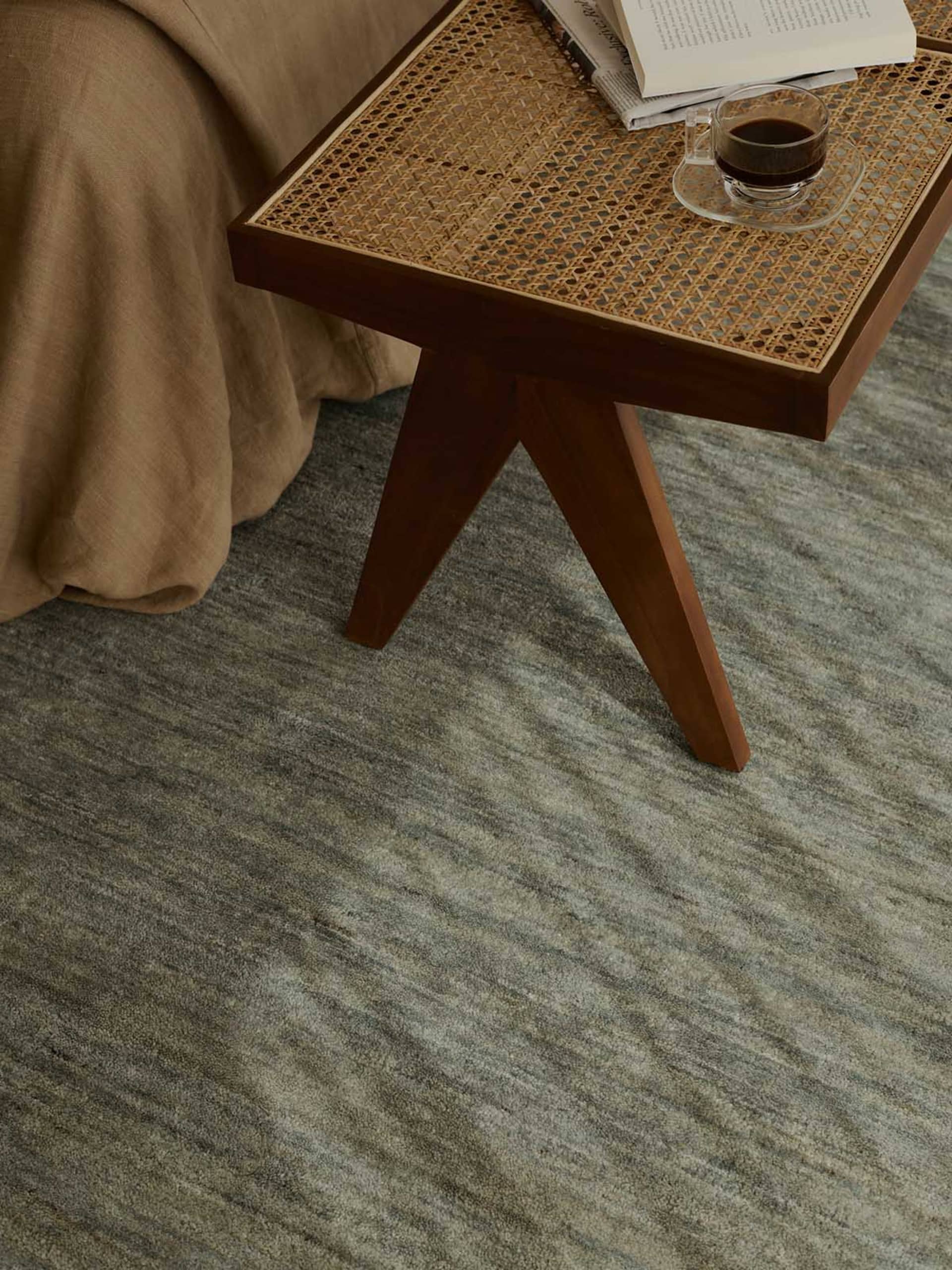 Cozy living room with a wooden coffee table, a rug, a couch, and a chair, with a warm and inviting atmosphere