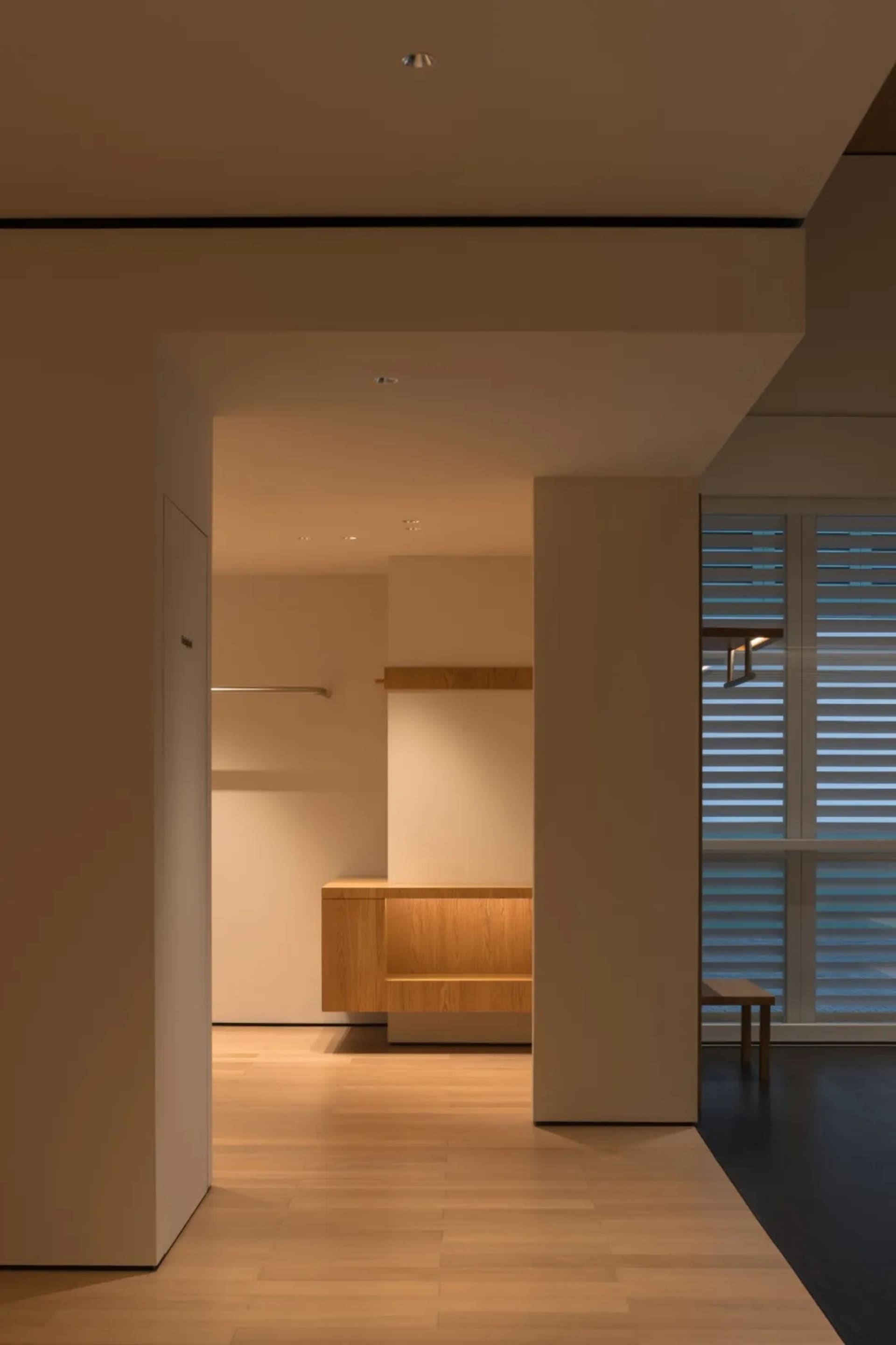Cozy modern kitchen with a wooden counter, sink, and bench in a dimly lit space