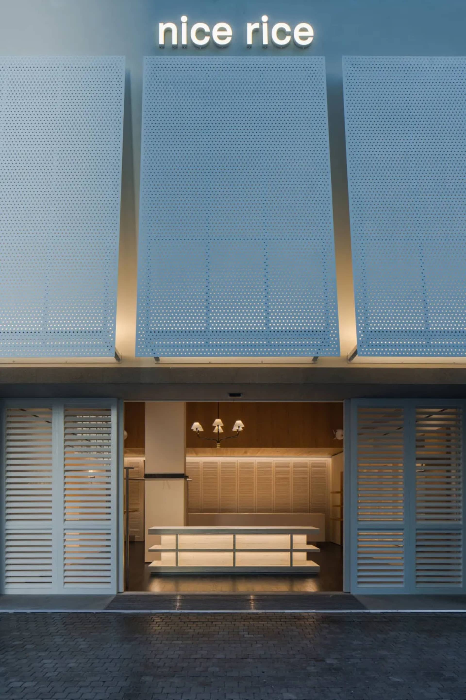 A modern lobby with a white bench and table, featuring a clean and simple design with predominantly white materials and well-balanced lighting
