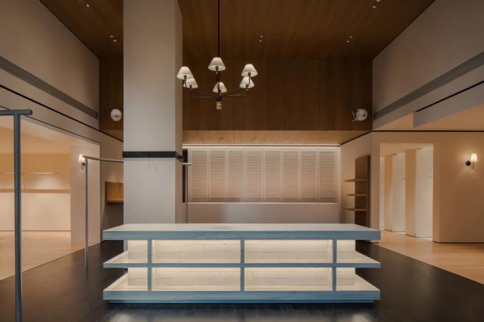 A clean and organized public space with a wooden floor, a white counter, and natural light from the windows