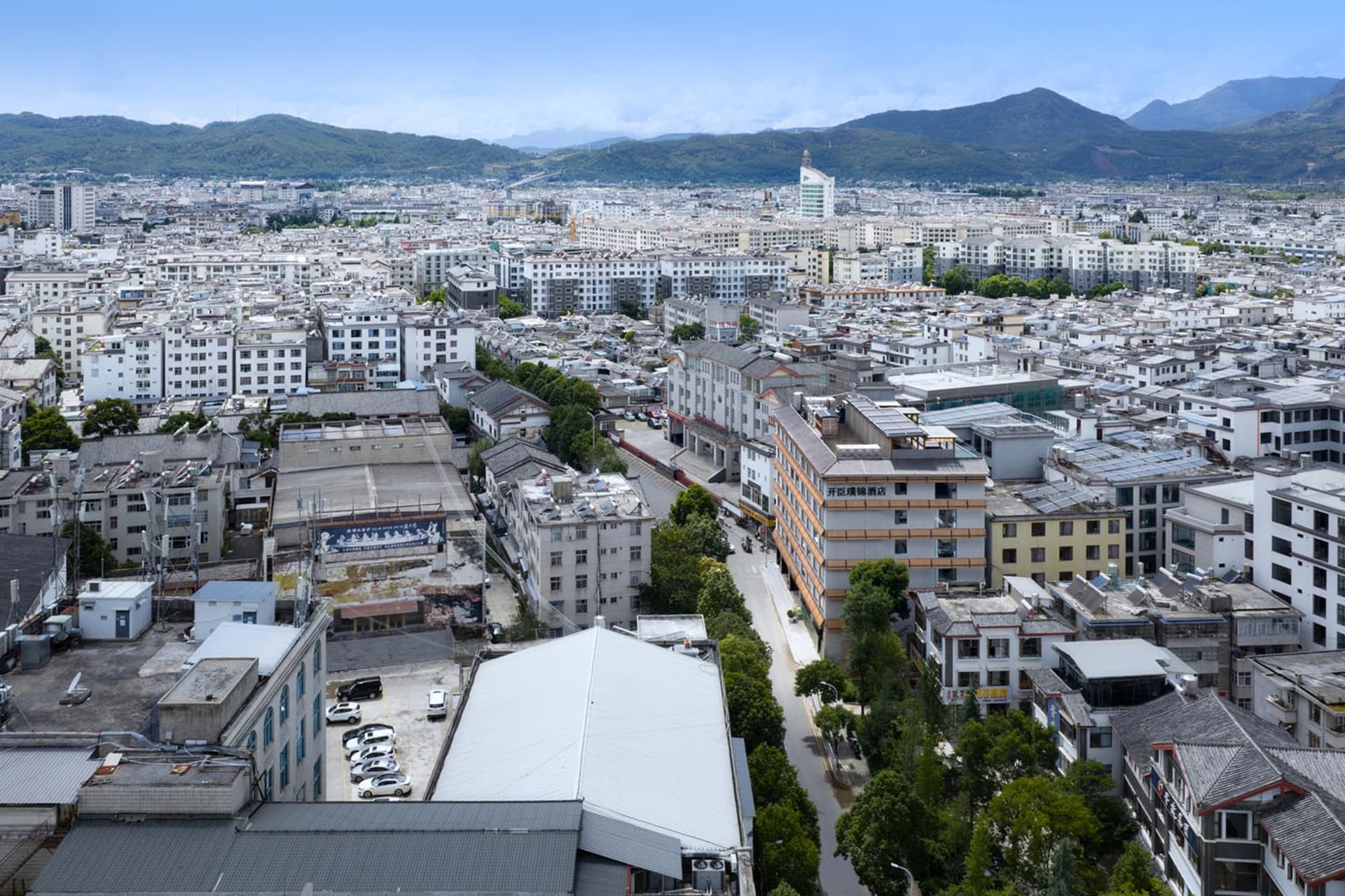 一座熱鬧的城市，有各種建築，包括公寓大樓和飯店，由混凝土、鋼材與玻璃建成，伴隨著繁忙街道與自然光線