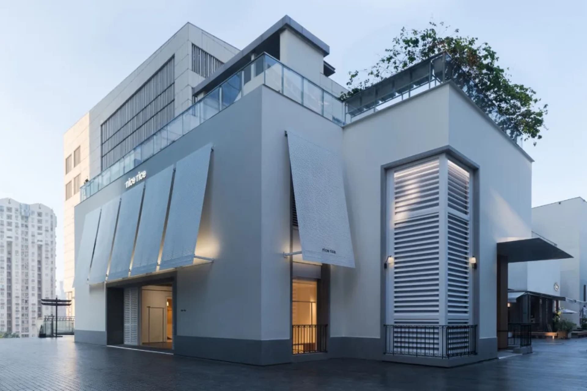 現代白色建築的照片，擁有大片窗戶與小窗戶，以混凝土建造，自然日光照射