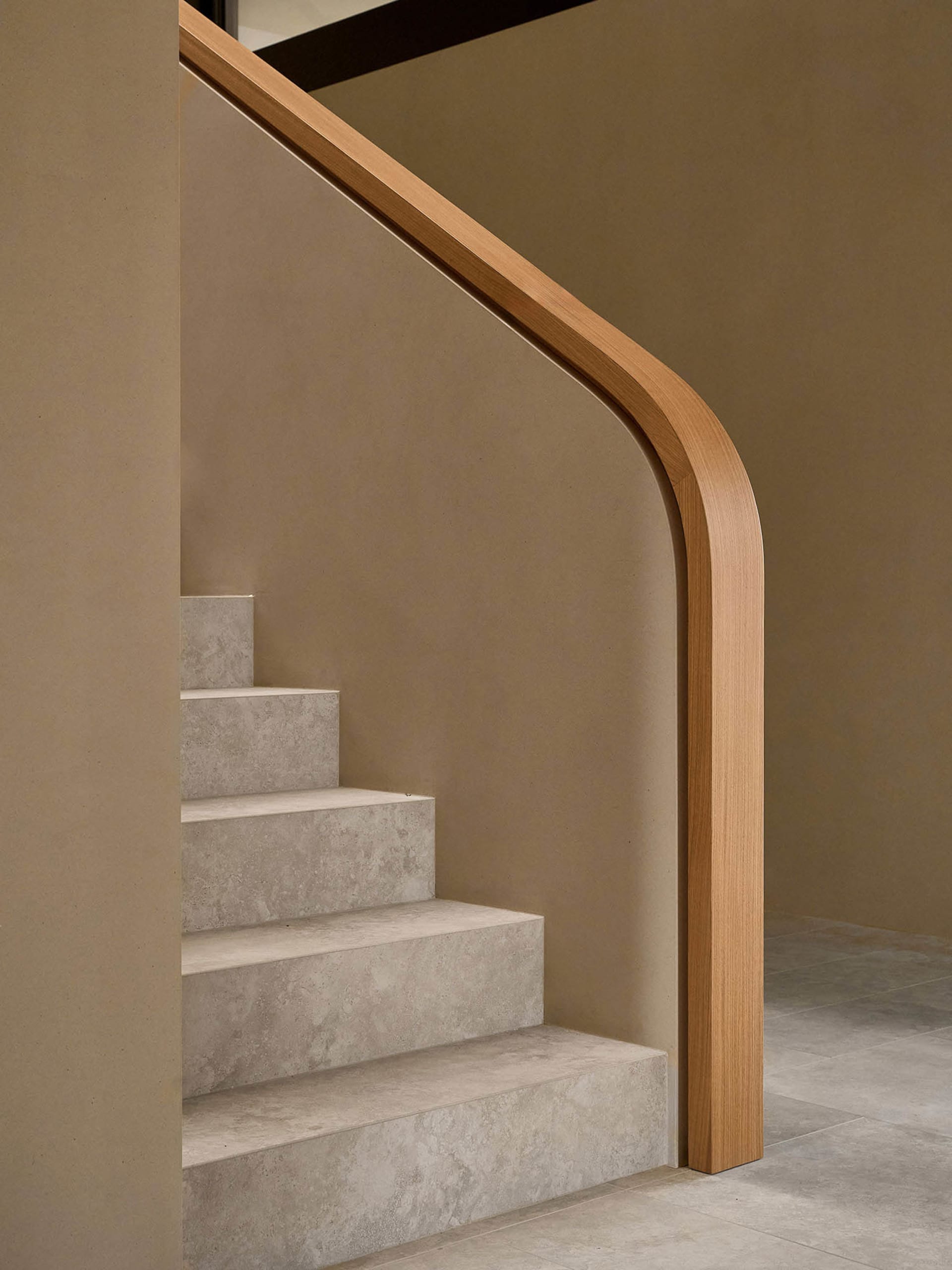 A modern staircase in a residential setting with a wooden staircase and brown color, surrounded by a calm and inviting atmosphere