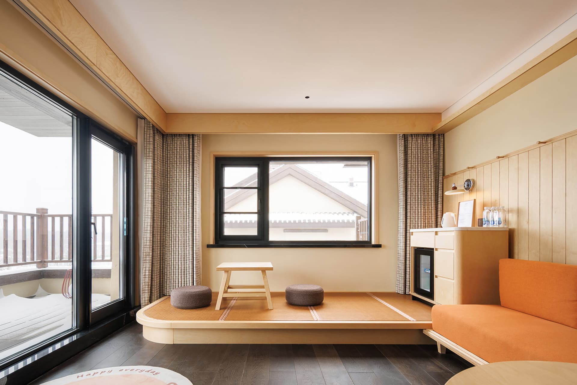 Cozy modern bedroom with a bed, table, and chair, featuring a wooden floor, walls, and furniture, with natural light from a window