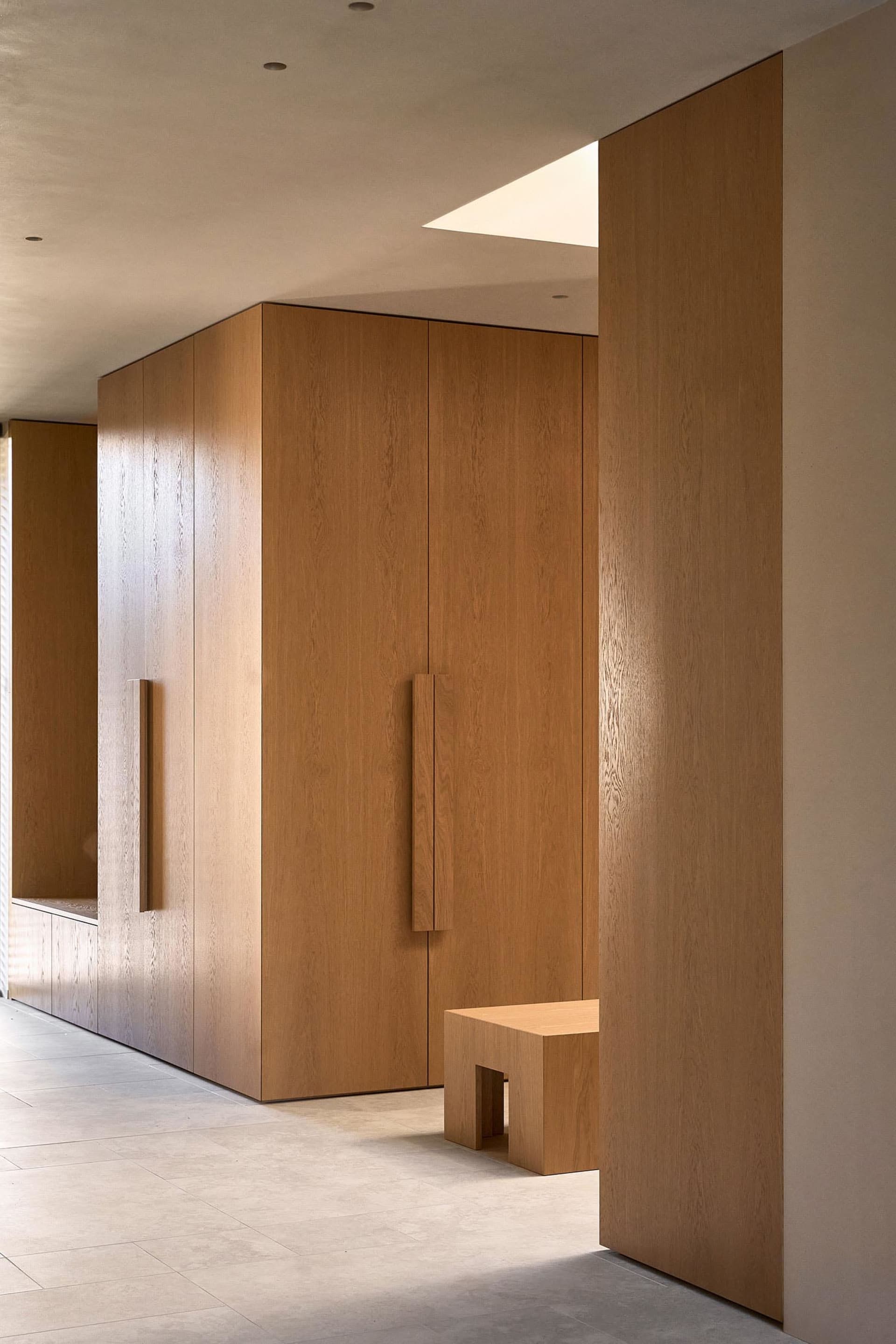 Well-lit hallway with wooden walls and doors, creating a warm and inviting atmosphere