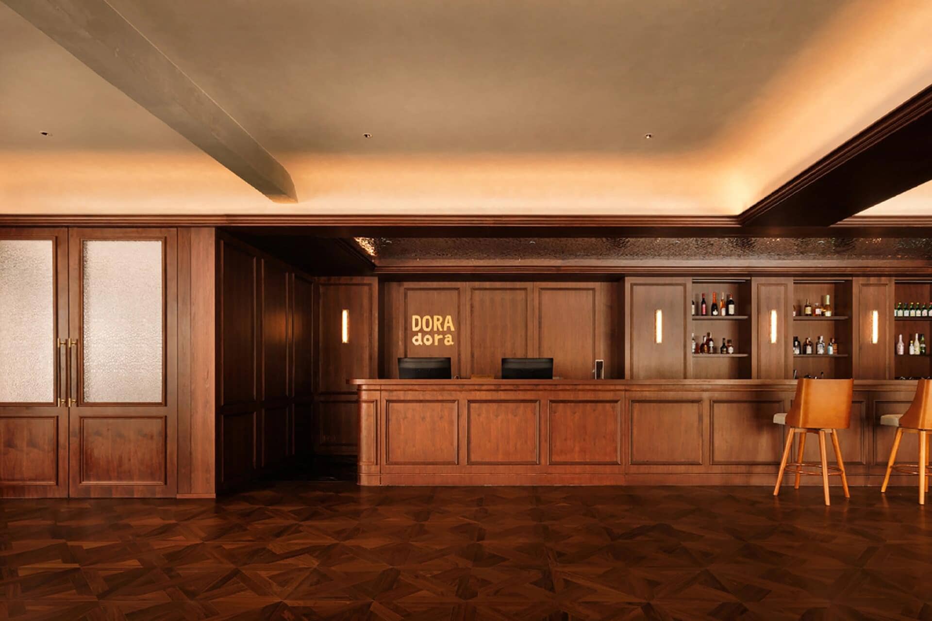 Well-lit lobby with a wooden floor and a wooden bar, featuring a counter and a sign
