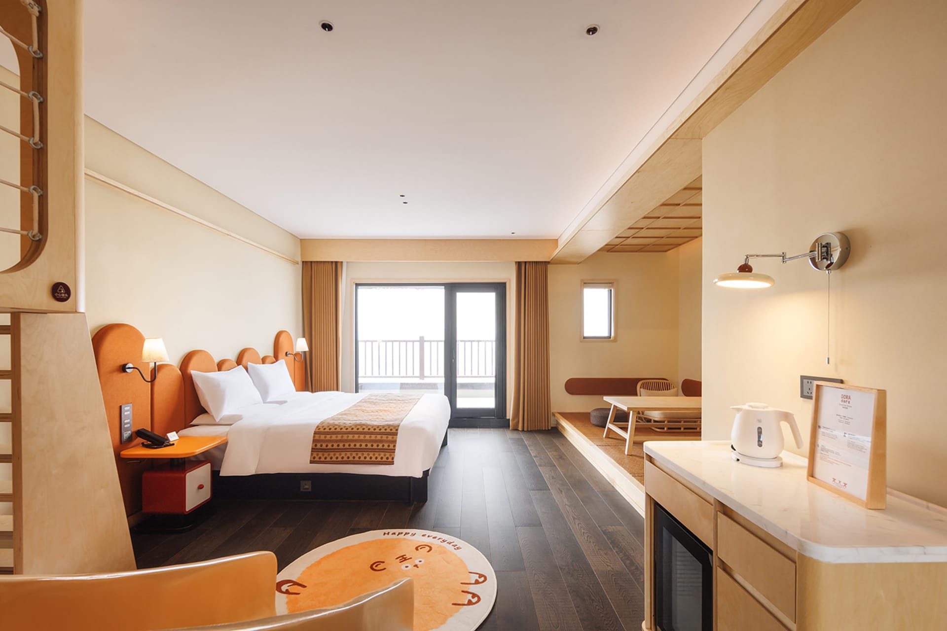 A modern bedroom with a bed, chair, and dining table, featuring wooden floors and natural light from a window