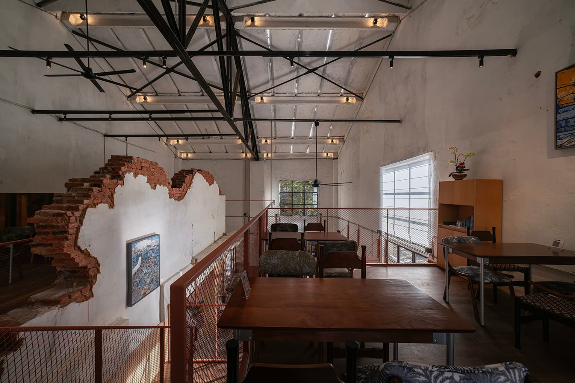 光線充足的餐廳餐區，配有木質地板、木桌與椅子，自然光線從窗戶灑入